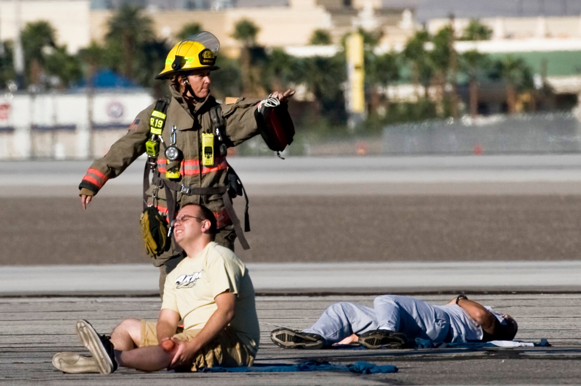 A Firefighter from the Clark County Fire Department requests help for a Nellis Airman acting as a casualty during the 2012 Triennial Emergency Preparedness Exercise at McCarran International Airport Oct. 24, 2012, in Las Vegas, Nev. The simulated major accident provided a realistic scenario for first responders to use procedures and emergency equipment if an actual mishap occurred.  (U.S. Air Force photo by Senior Airman Daniel Hughes)

