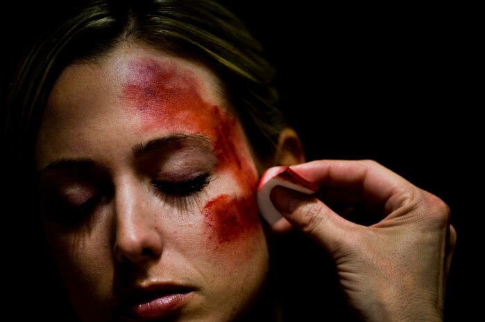 U.S. Air Force Staff Sgt. Brittany Behnke, 57th Maintenance Squadron precision guided munitions crew chief, has makeup applied to her face before participating in 2012 Triennial Emergency Preparedness Exercise conducted by the Clark County Department of Aviation at McCarran International Airport Oct. 24, 2012, in Las Vegas, Nev.  More than 60 Airmen from Nellis Air Force Base, Nev. acted as casualties to help provide a realistic training environment for first responding crews. (U.S. Air Force photo by Senior Airman Daniel Hughes)