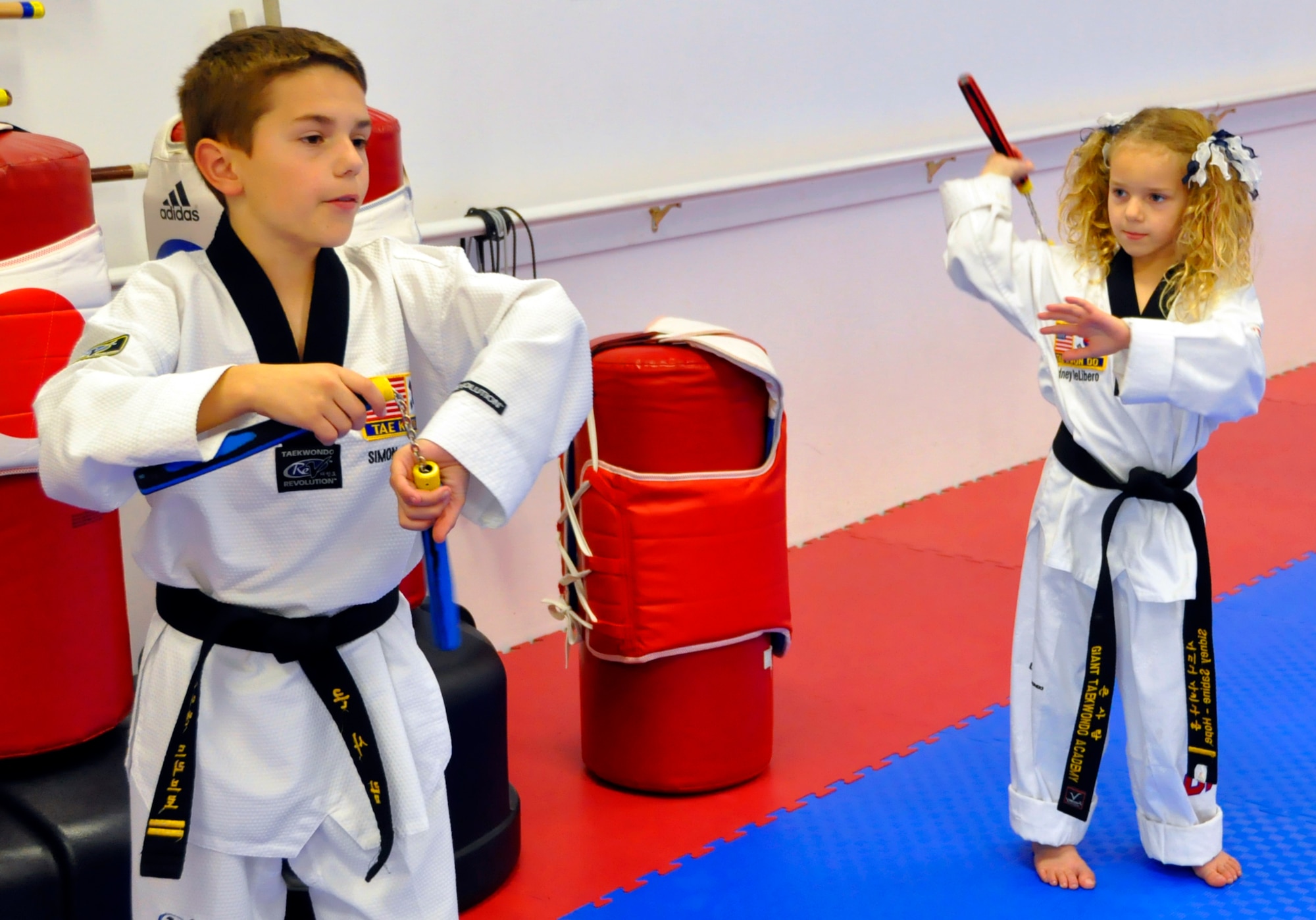 Simon DeLibero, a 446th Airlift Wing Reservist's son, practices nunchuck skills with his sister, Sidney, at a taekwondo school in Edgewood, Wash., Oct. 17. Activities like taekwondo helped Simon, a second-degree black belt, and his sister, a first-degree black belt, get through their father's military responsibilities away from home. (U.S. Air Force photo/Staff Sgt. Rachael Garneau)