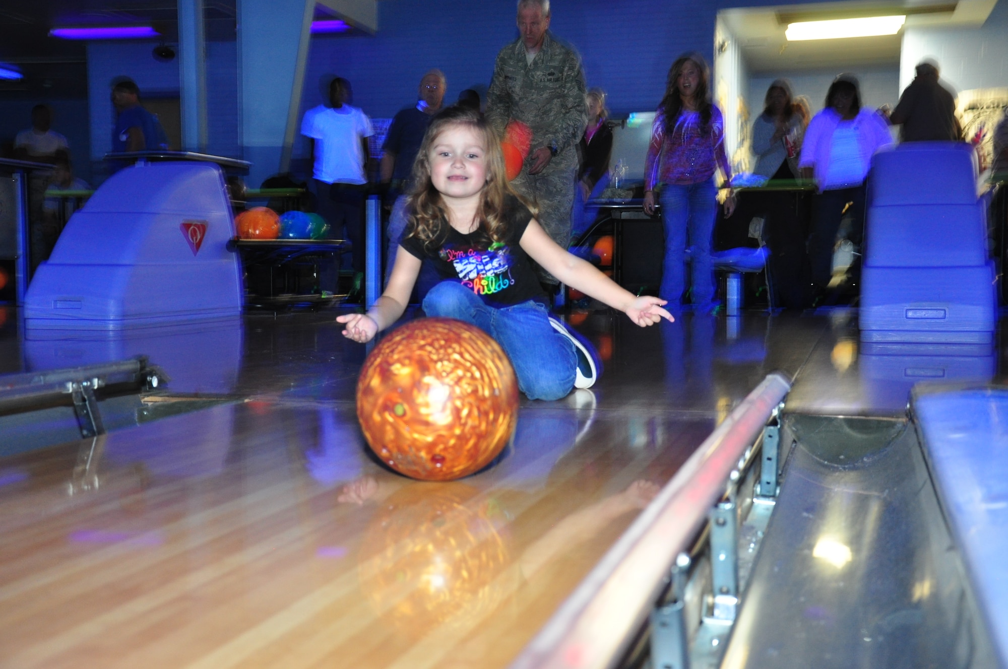 Vivienne Anderson, 3, granddaughter of Kathy McCoole, Warren’s Assistant Sexual Assault Response Coordinator, rolls her ball down the bumper-lined lane Oct. 9 as her family and teammates look on. (U.S. Air Force photo by Senior Airman Mike Tryon)