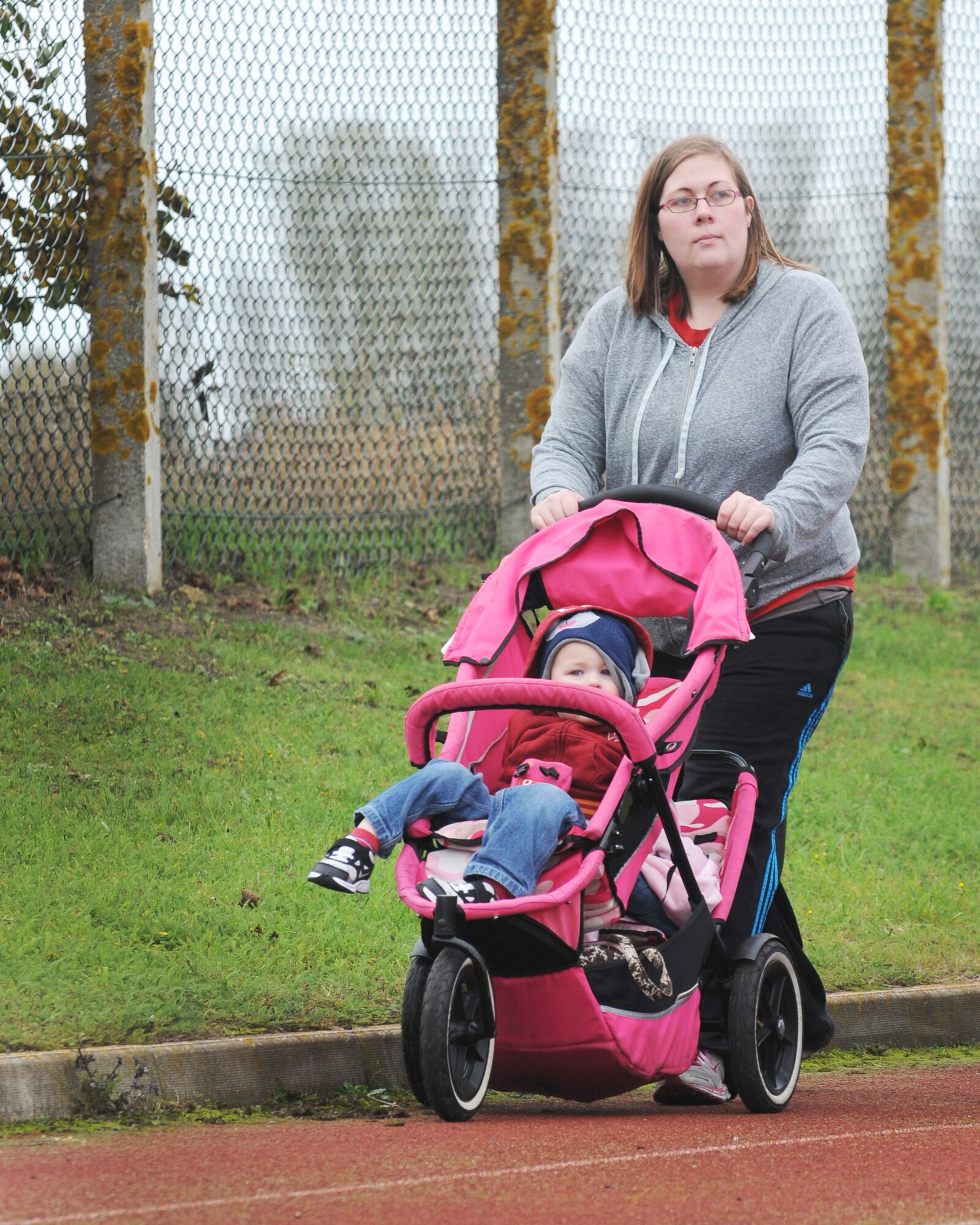 Mackenzie Kent, 100th Communication Squadron spouse, pushes a stroller around the track during the Wear Pink Breast Cancer Awareness 5/10K Walk Oct. 26, 2012, at RAF Mildenhall, England.  Approximately 200 base members attended the walk to support Breast Cancer Awareness Month.  (U.S. Air Force photo by Staff Sgt. Tabitha M. Lee/Released)