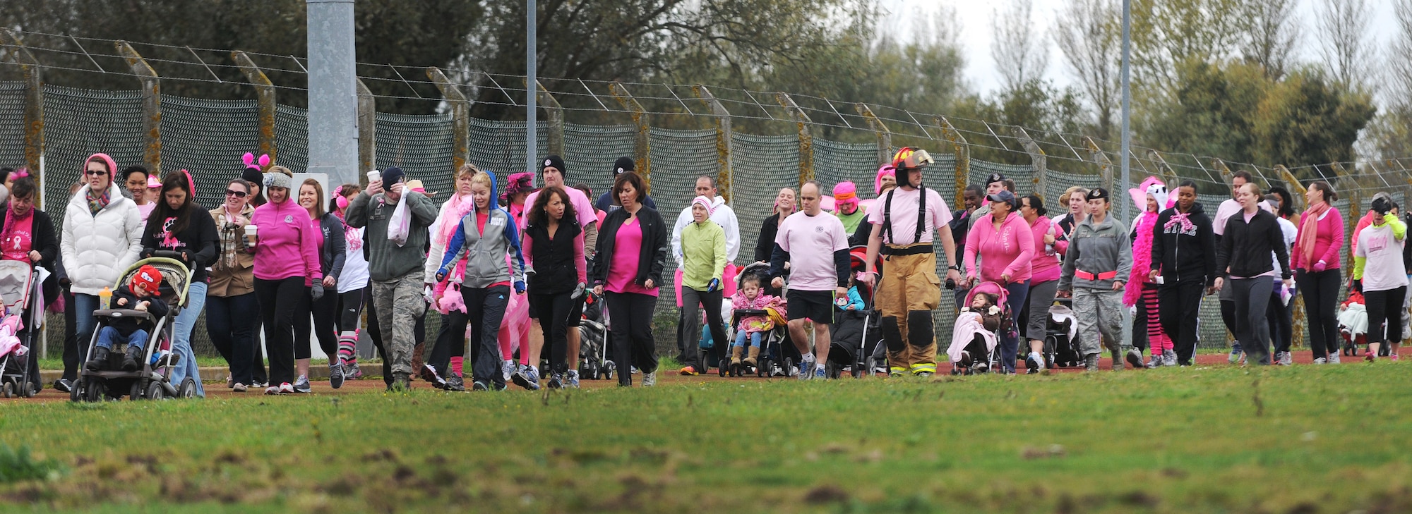 Base members wear pink attire while walking the track during the Wear Pink Breast Cancer Awareness 5/10K Walk Oct. 26, 2012, at RAF Mildenhall, England.  The event was organized by the Bob Hope Community Center in support of Breast Cancer Awareness Month.  (U.S. Air Force photo by Staff Sgt. Tabitha M. Lee/Released)