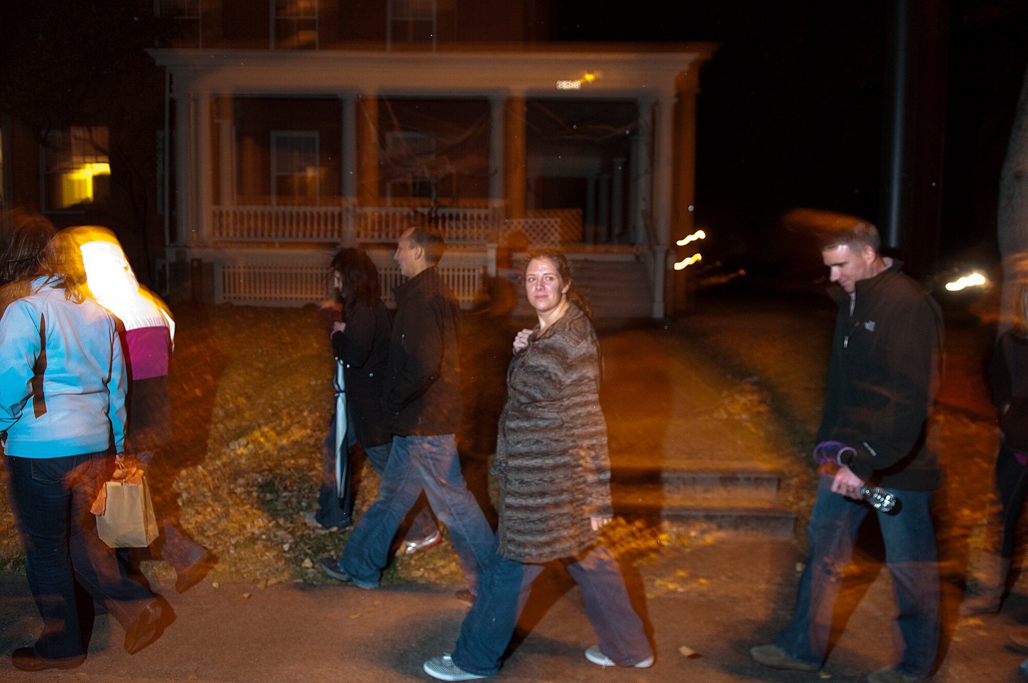 Some of the 61 participants in the Warren Spouse Club ghost tour walk through the historic brick housing section of F. E. Warren Air Force Base, Wyo., Oct. 16. Guides led groups through the neighborhood telling them of the ghosts some believe inhabit the older houses on the base. (U.S. Air Force photo by R.J. Oriez)