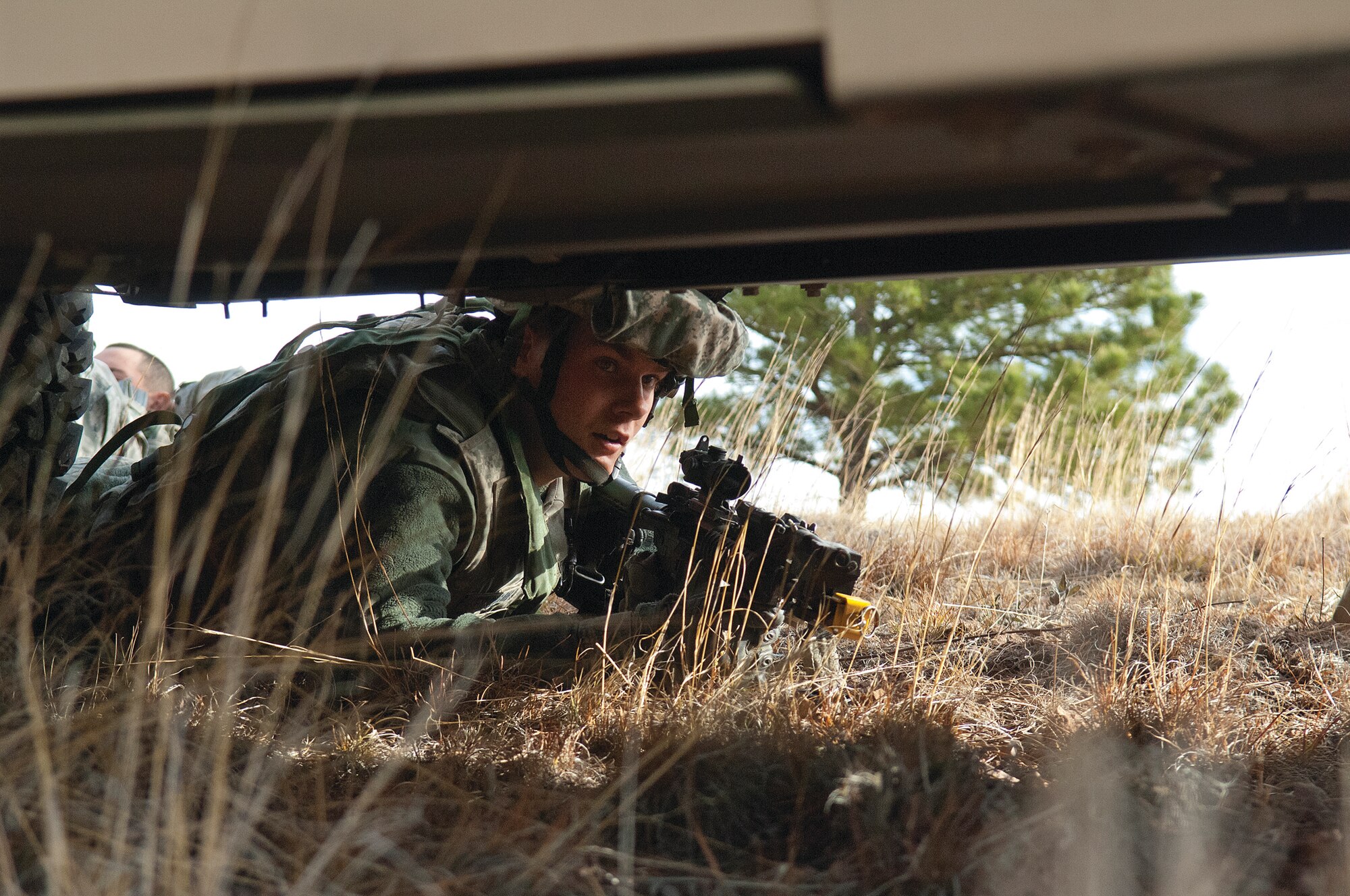 Airmen 1st Class Owen Erickson, 790th Missile Security Forces Squadron, peers from under a Humvee looking for the opposition forces during Road Warrior X, a training exercise conducted by the 620th Ground Combat Training Squadron at Camp Guernsey, Wyo., Oct. 19. (U.S. Air Force photo by R.J. Oriez)