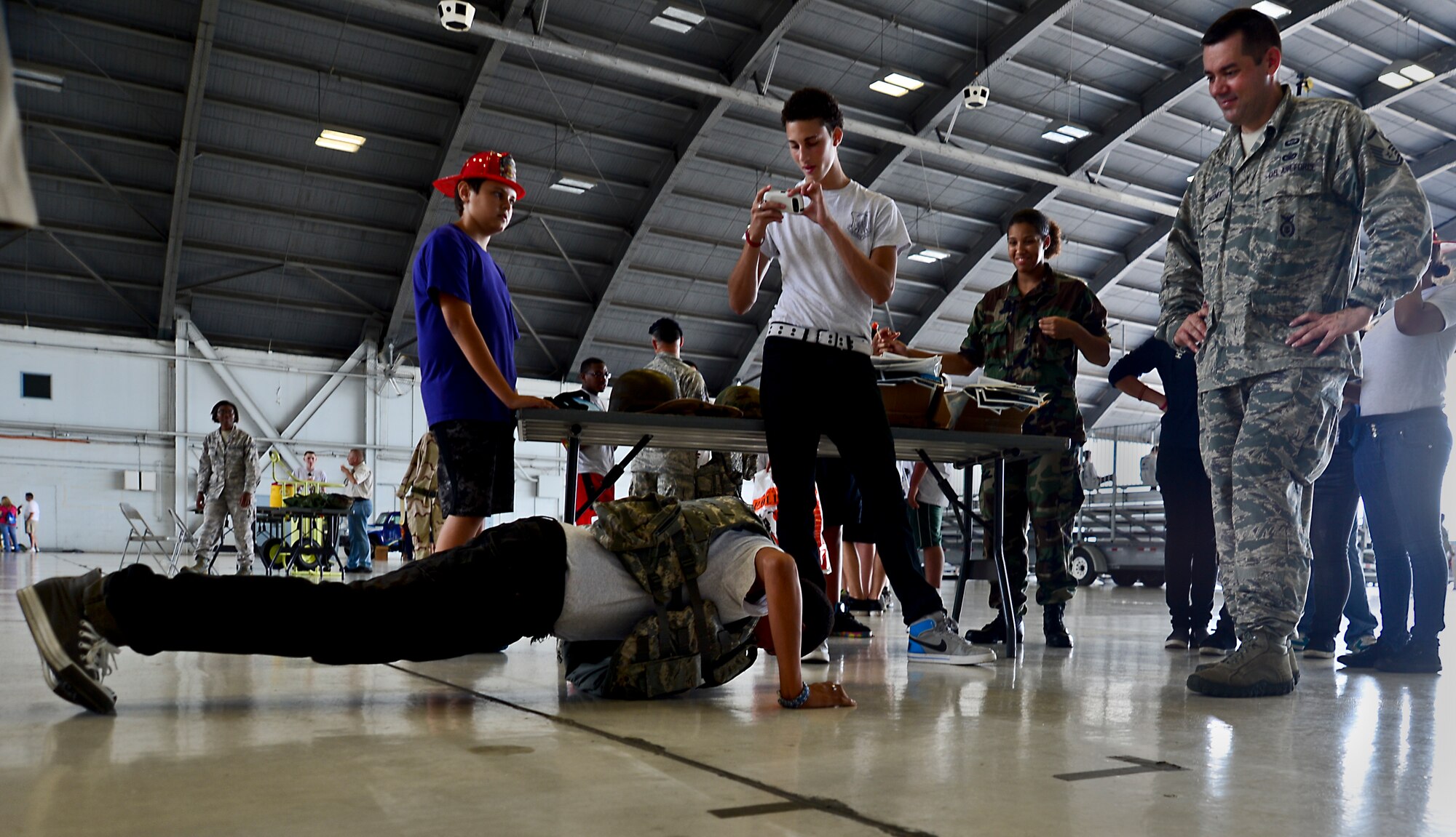 A student from Wekiva High School Louis Sarmiento performs push-ups in a flak vest while Master Sgt. Patrick McSweeney, 6th Security Forces NCO in charge of operations support, counts repetitions during ROTC Day Oct. 19, 2012, at MacDill Air Force Base, Fla. Coordination between multiple base agencies led to the display of a KC-135 Stratotanker, a security forces marine patrol boat and a mock deployment tent. (U.S. Air Force photo by Airman 1st Class Melanie Bulow-Kelly/Released)    