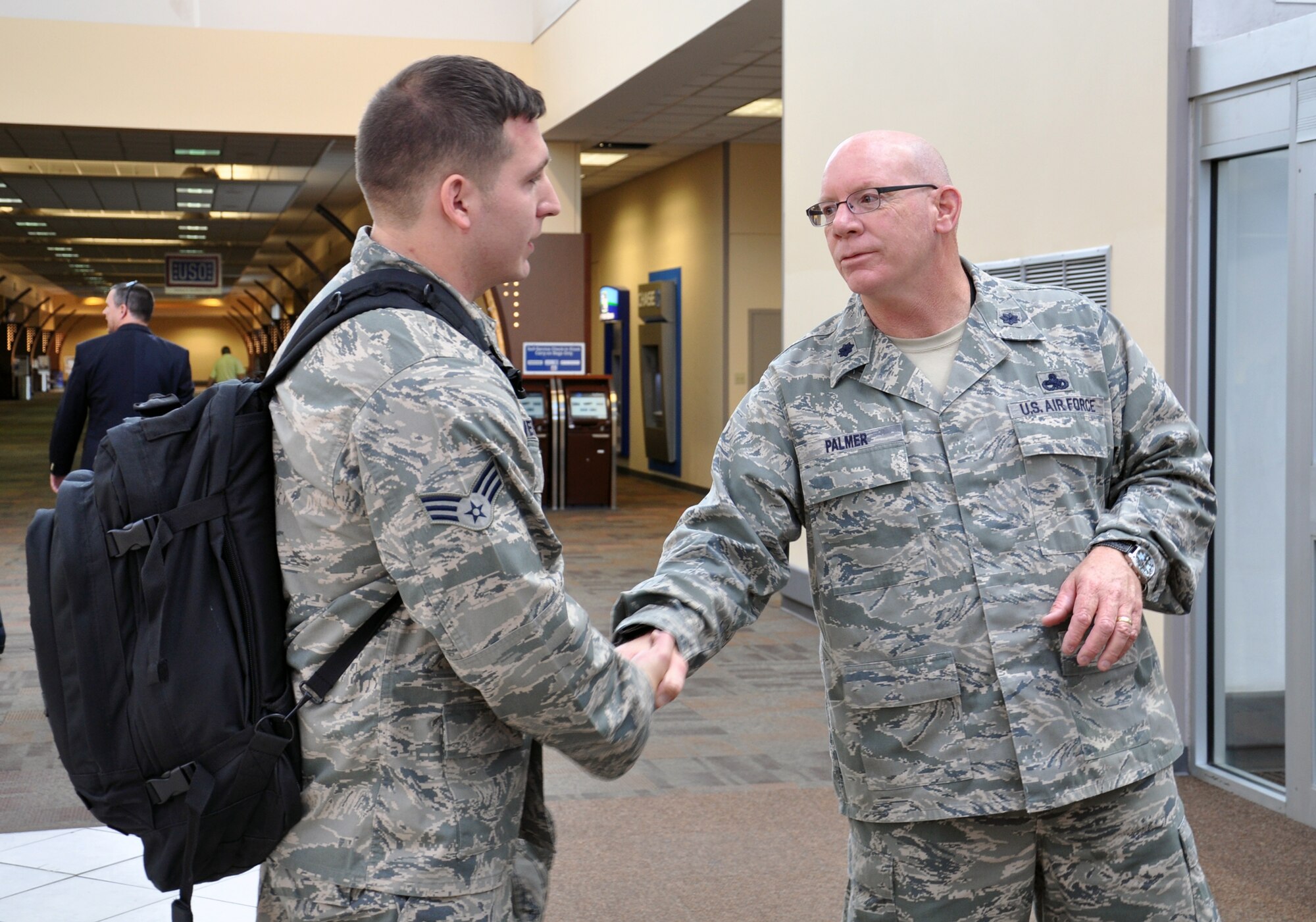 WRIGHT-PATTERSON AIR FORCE BASE, Ohio – Senior Airman Nick Harvey, 445th Aircraft Maintenance Squadron information knowledge management journeyman, is coined by Lt. Col. George Palmer, 445th AMXS commander, at the Dayton International Airport Oct. 25 for a job well done after returning from a six-month deployment to Southwest Asia. Harvey was assigned to the 379th Air Expeditionary Wing. (U.S. Air Force photo/Stacy Vaughn)