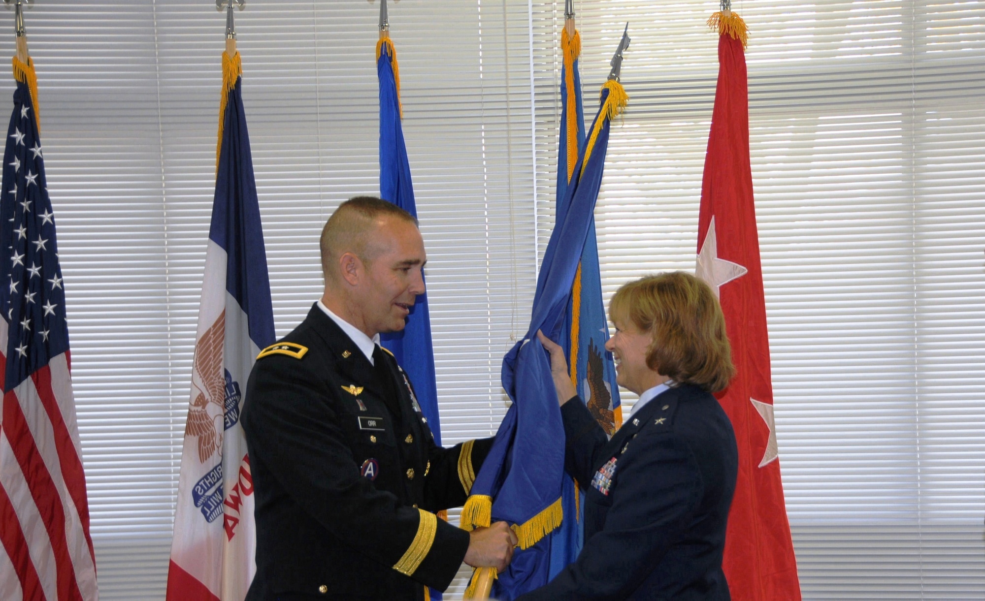 Maj. Gen. Tim Orr (left) Adjutant General of the Iowa National Guard, presents a General Officer flag to Brig. Gen. Jennifer Walter (right) at her promotion ceremony to Brigadier General on Oct. 14, 2012 at the 132nd Fighter Wing (132FW), Iowa Air National Guard, Des Moines, Iowa. Brig. Gen. Walter is the first female General Officer in the history of the Iowa Air National Guard. (US Air Force photo/Master Sgt Robert P. Shepherd)(Released)