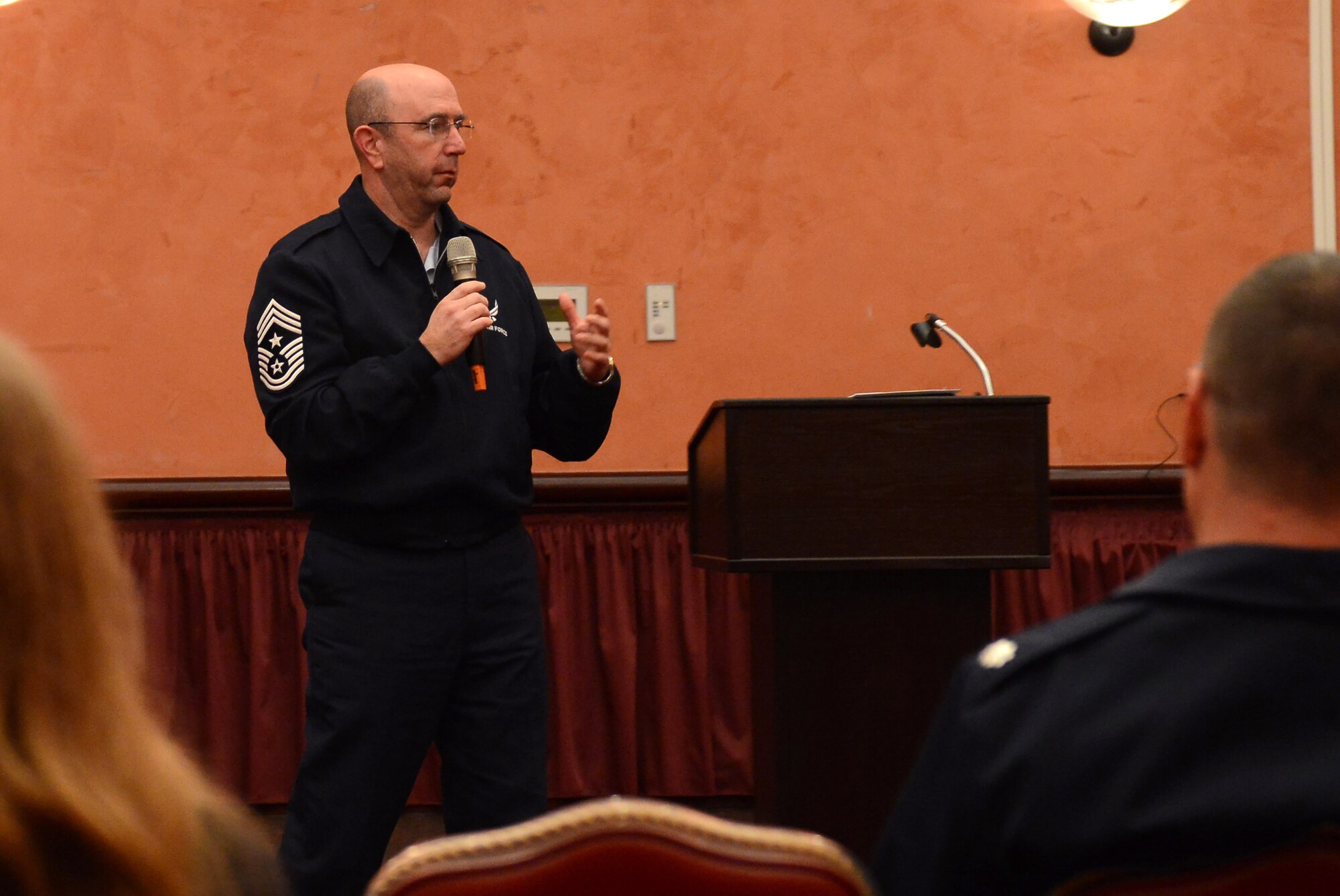 Chief Master Sgt. Jeffrey Craver, 31st Fighter Wing command chief, speaks during a town hall meeting Oct. 22 at the La Bella Vista Club, Aviano Air Base, Italy. To make the town hall more accessible, Team Aviano members could attend the town hall, listen to it aired live on American Forces Network Aviano, or recieve updates via Facebook.  (U.S. Air Force photo by Senior Airman Katherine Tereyama)
