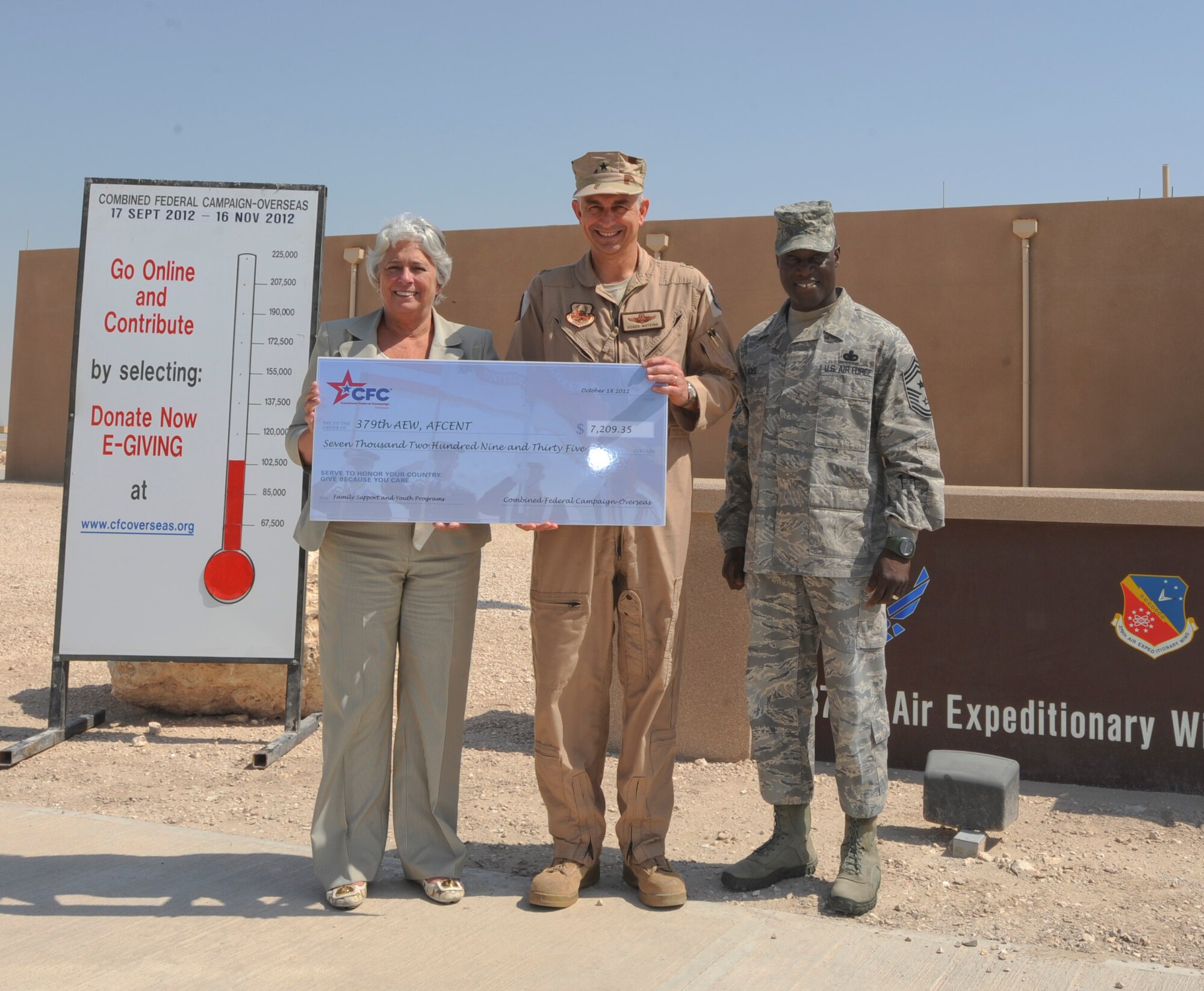 Rene Acosta, Global Impact president, presented a check Oct. 18, 2012 for $7,209.35 to Brig. Gen. Roger Watkins, 379th Air Expeditionary Wing commander, and Chief Master Sgt. Rory Wicks, 379th AEW command chief, to go toward the Family Support and Youth Program here. The local community donated these funds during last year’s CFC-O campaign to help improve the quality of life at the 379th AEW. Some of the funds from past years have been used to replace treadmills, provide equipment to record service members reading stories to their children and various other quality of life functions. (U.S. Air Force photo/Senior Airman Bryan Swink)