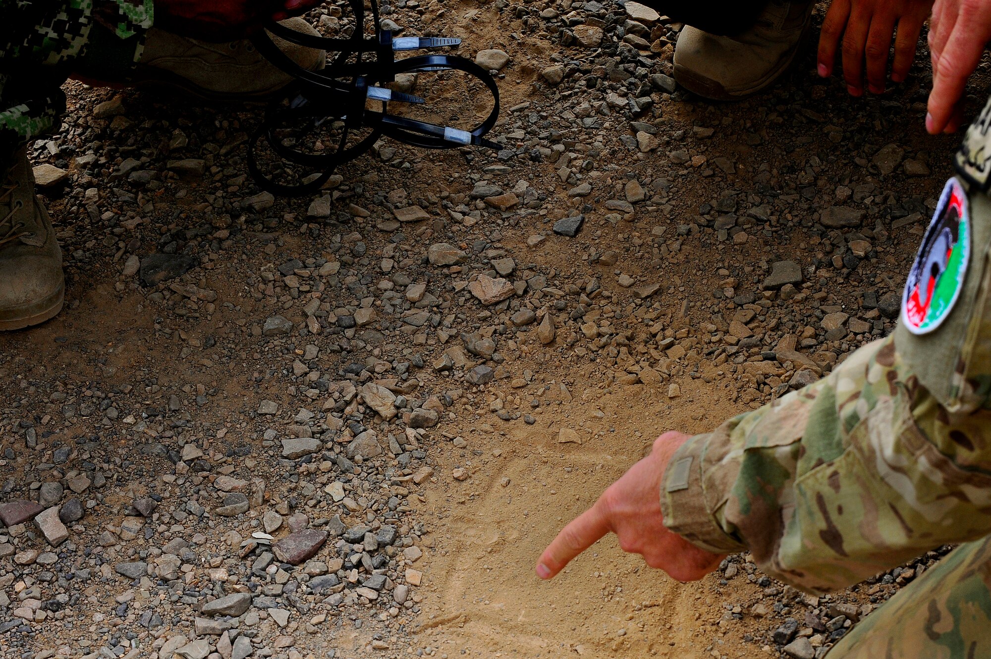 U.S. Air Force Senior Master Sgt. Ryan Sprauer, Security Forces advisor, draws up strategic positions to show Afghan Security Forces members during a field training exercise, Oct. 18, 2012 at Shindand Air Base, Afghanistan. This was an initial security and tactical training culmination exercise for the Shindand Air Wing Security Forces. (U.S. Air Force photo/ Tech. Sgt. Quinton Russ/RELEASED)