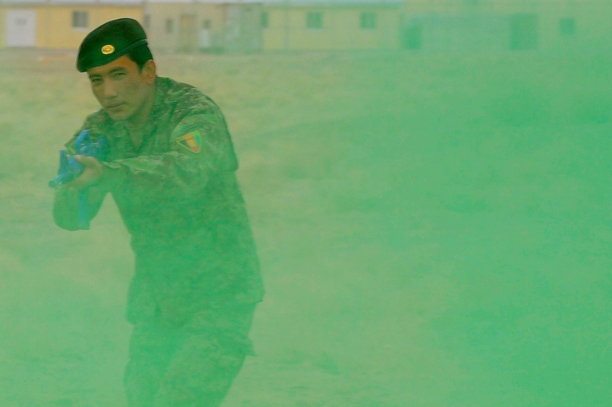 Afghan Air Force Security Forces Sgt. Nagi Bullah runs through smoke after a simulated attack during a field training exercise, Oct. 18, 2012, at Shindand Air Base, Afghanistan. This was an initial security and tactical training culmination exercise for the Shindand Air Wing Security Forces. (U.S. Air Force photo/ Tech. Sgt. Quinton Russ/RELEASED)