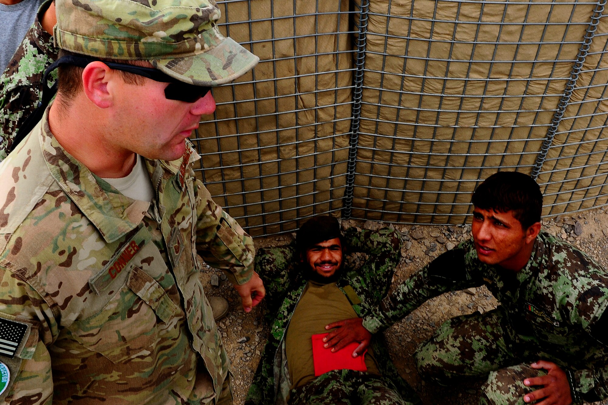 U.S. Air Force Tech. Sgt. Jeremy Connor, advisor, and Afghan AF Security Forces Soldier Noor Alam communicate about self-aid and buddy care during field training, Oct. 18, 2012, at Shindand Air Base, Afghanistan. This was an initial security and tactical training culmination exercise for the Shindand Air Wing Security Forces. (U.S. Air Force photo/ Tech. Sgt. Quinton Russ/RELEASED)