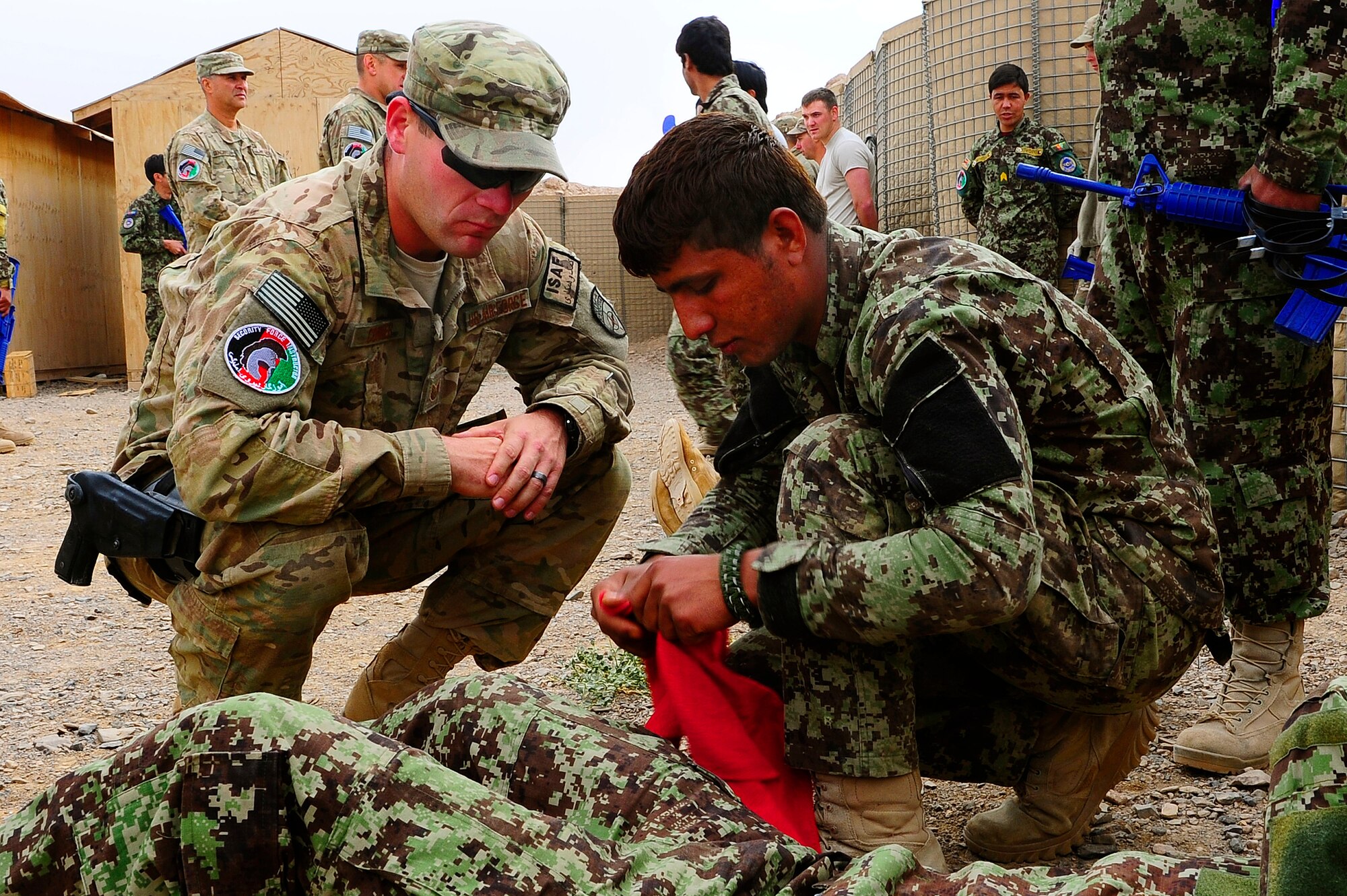 U.S. Air Force Tech. Sgt. Jeremy Connor, advisor, watches as Afghan AF Security Forces Soldier Noor Alam makes a bandage during field training, Oct. 18, 2012, at Shindand Air Base, Afghanistan. This was an initial security and tactical training culmination exercise for the Shindand Air Wing Security Forces. (U.S. Air Force photo/ Tech. Sgt. Quinton Russ/RELEASED)