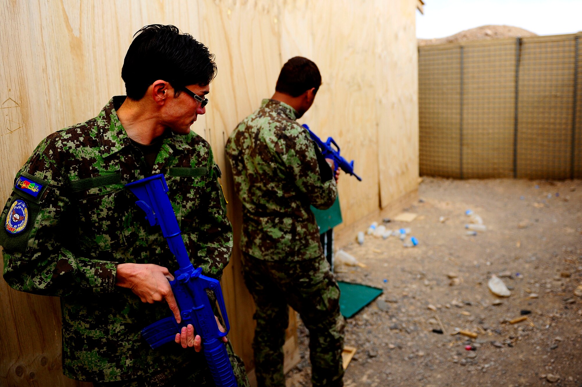 Afghan Air Force Security Forces Soldier Qasim watches as Soldier Noor Alam clears the corner of a building during field training, Oct. 18, 2012 at Shindand Air Base, Afghanistan. This was an initial security and tactical training culmination exercise for the Shindand Air Wing Security Forces. (U.S. Air Force photo/ Tech. Sgt. Quinton Russ/RELEASED)
