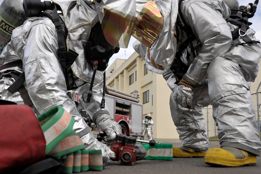 U.S. Air Force firefighters from the 35th Civil Engineer Squadron connect hoses as they prepare to put out a simulated fire during a Prime Base Engineer Emergency Forces exercise at Misawa Air Base, Japan, Oct. 18, 2012. Prime BEEF are civil engineer forces organized for direct combat support or emergency recovery from natural disasters. (U.S. Air Force photo by Staff Sgt. Nathan Lipscomb)