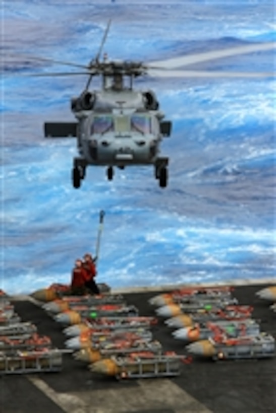 A U.S. Navy MH-60S Sea Hawk helicopter approaches the flight deck of the aircraft carrier USS Enterprise (CVN 65) for another load of ammunition as the ship conducts an ammunition offload in the Atlantic Ocean on Oct. 25, 2012.  Enterprise is completing its final deployment to the U.S. 5th and 6th Fleet areas of responsibility in support of maritime security operations and theater security cooperation efforts.   The Sea Hawk is attached to Helicopter Sea Combat Squadron 28.  