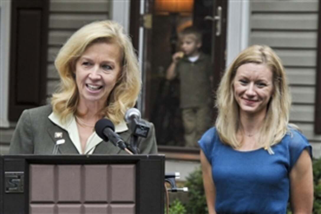 Allison A. Hickey, left, Veterans Affairs undersecretary for benefits, awards the department's 20 millionth home loan to Elizabeth Carpenter, the widow of Army Cpt. Matthew Carpenter, at her new home in Woodbridge, Va., Oct. 26, 2012. President Franklin D. Roosevelt launched the VA's home loan program when he signed the G.I. Bill of Rights in 1944. Carpenter's son, Joey, stands in the doorway.