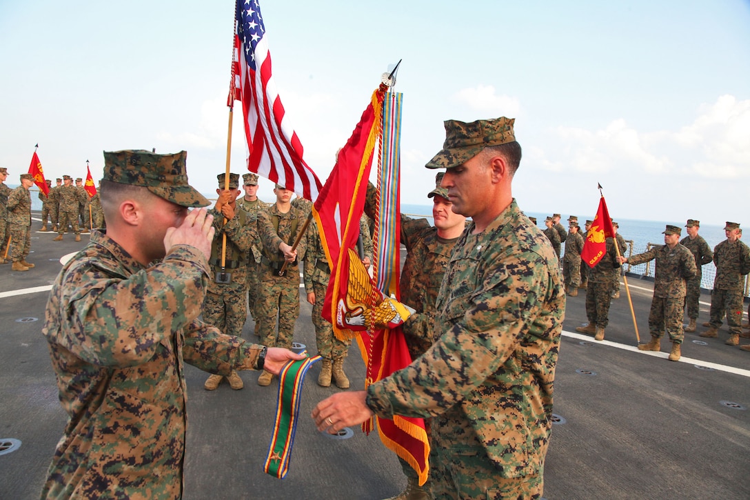 Lieutenant Col. John Wiener (right), commanding officer, Combat Logistics Battalion 15, 15th Marine Expeditionary Unit, accepts a unit citation in order to rededicate the unit’s battle colors during their 25th birthday aboard the USS Rushmore, Oct. 15. The 15th MEU along with the Peleliu Amphibious Ready Group, which includes the USS Rushmore, USS Peleliu and USS Green Bay, is currently deployed to the Western Pacific.