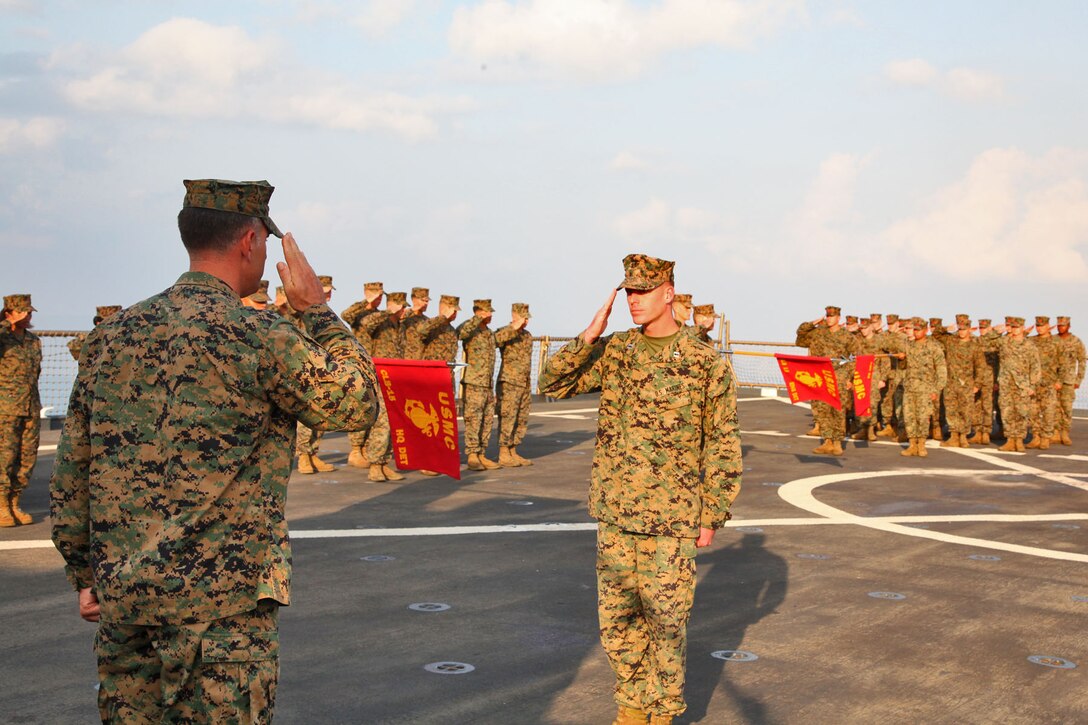 Lieutenant Col. John Wiener (left), commanding officer, Combat Logistics Battalion 15, 15th Marine Expeditionary Unit, returns a salute during the CLB’s 25th birthday aboard the USS Rushmore, Oct. 15. The 15th MEU along with the Peleliu Amphibious Ready Group, which includes the USS Rushmore, USS Peleliu and USS Green Bay, is currently deployed to the Western Pacific.