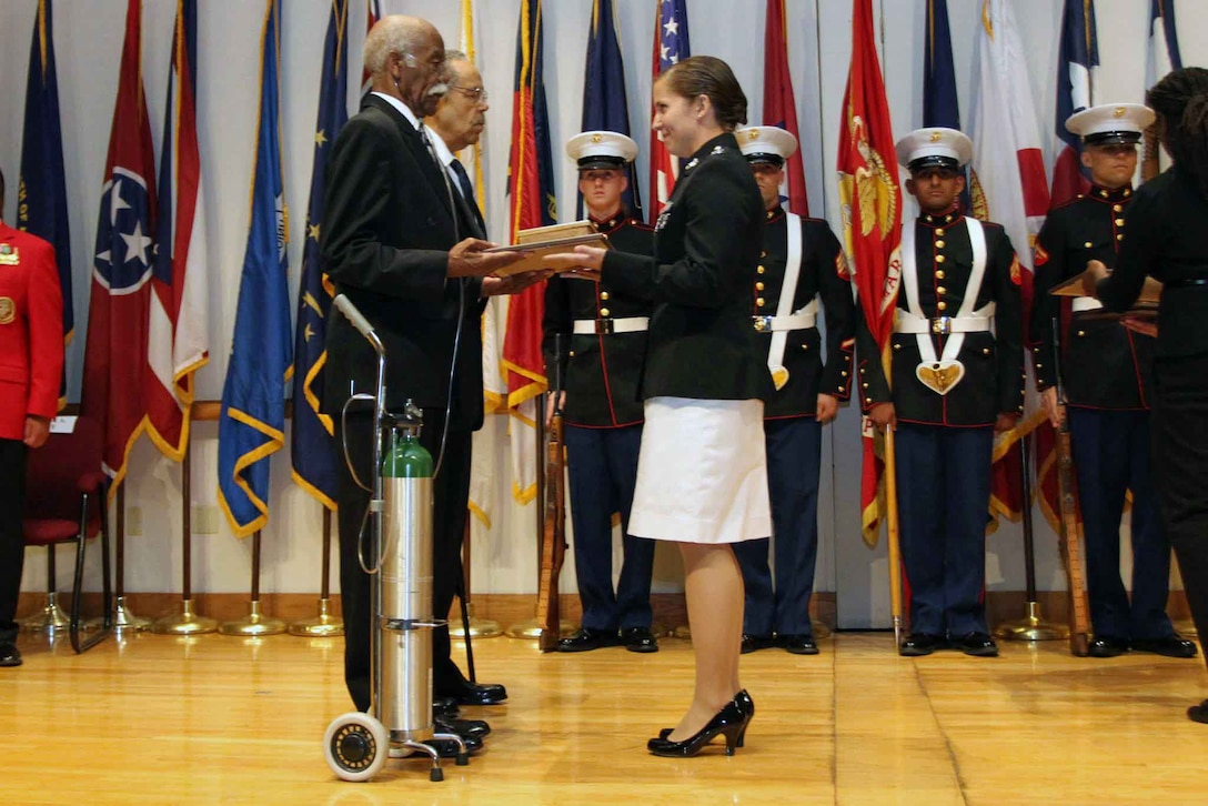 Montford Point Marines Sgt. Riley A. McCray and Cpl. Lynn L. Williams are presented with the Congressional Gold Medal by Capt. Caitlin T. Ferrarell at a ceremony here Sept. 21. Ferrarell is the Inspector-Instructor for Detachment 2, Beach and Terminal Operations Company A, 4th Landing Support Battalion, 4th Marine Logistics Group, in Concord, Calif. The pair earned the award by presidential order for being a few of the 22,000 African-American Marines to serve in the Corps between 1942 and 1949 during a time of common racism and segregation. Marine Reserve units from 22 states around the nation have been tasked to deliver 78 medals to Montford Point Marines who weren’t in attendance at the July ceremony in Washington, D.C. 