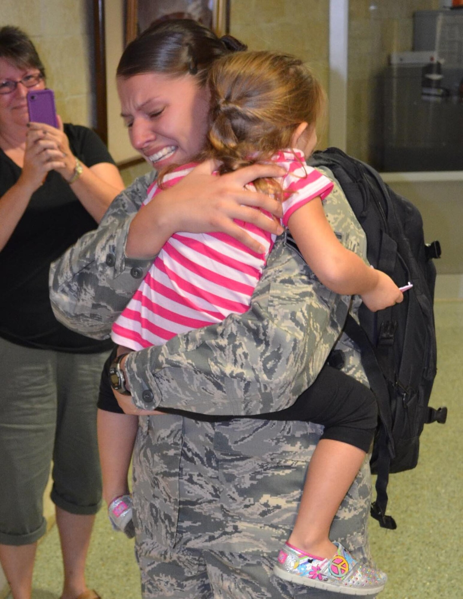 Staff Sgt. Carolina Flores, 433rd Sercurity Forces Squadron, emotionally hugs her daughter Abby, at the San Antonioal International Airport on Oct. 25, 2012. Twenty-five 433 SFS Airmen returned from a nearly seven month deployment to Eskan Village, Saudi Arabia. The Airmen provided integrated defense, emergency response, and combat support for the base which houses military and host nation tentant agencies. (U.S. Air Force Photo/Maj. Tim Wade)