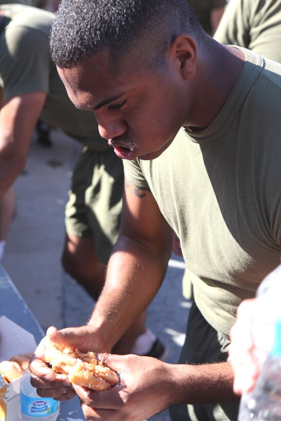 A participant in 2nd Maintenance Battalion, 2nd Marine Logistics Group’s doughnut-eating challenge inhales a stack of three doughnuts during the unit’s field meet aboard Camp Lejeune, N.C., Oct. 24, 2012. Participants volunteered to eat twelve doughnuts and run a total of three miles as they fought to win the fastest times for their companies. 