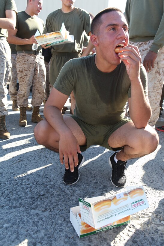 A participant in 2nd Maintenance Battalion, 2nd Marine Logistics Group’s doughnut-eating challenge forces another bite into his mouth during the unit’s field meet aboard Camp Lejeune, N.C., Oct. 24, 2012. Participants volunteered to eat twelve doughnuts and run a total of three miles during the challenge – a feat which upset more than a few stomachs. 