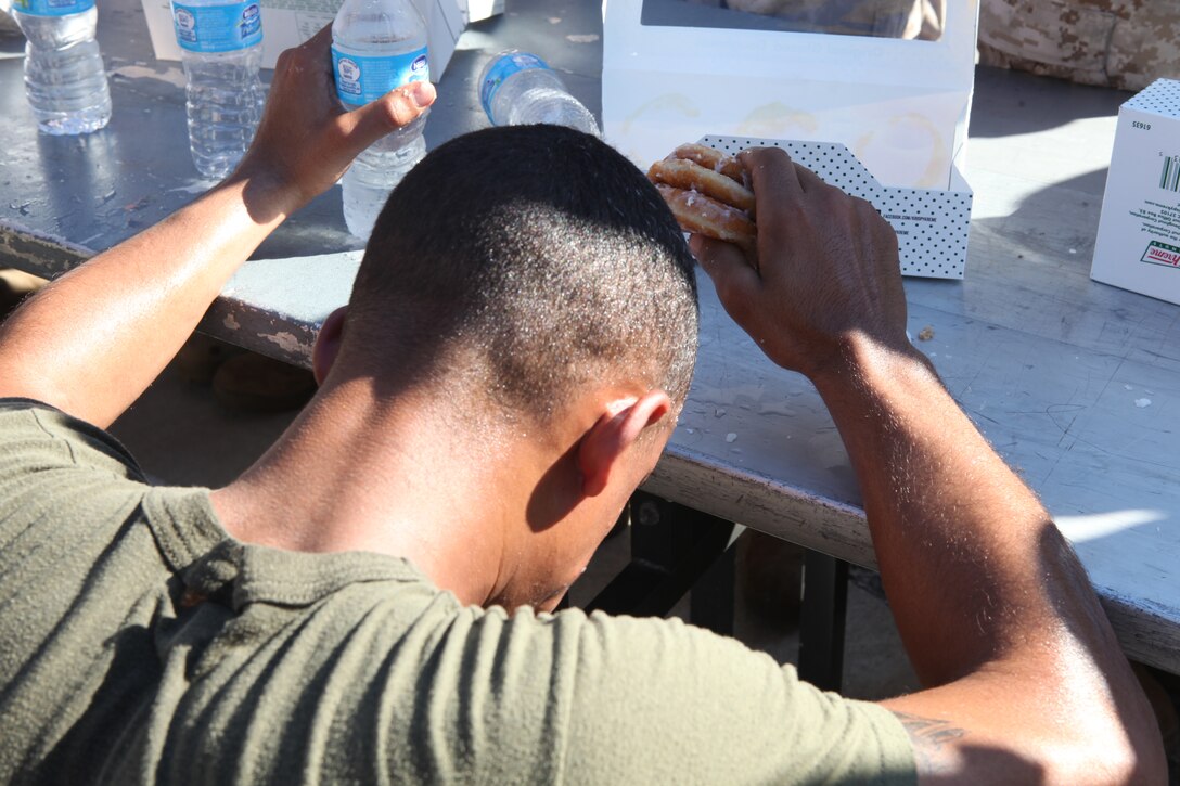 A participant in 2nd Maintenance Battalion, 2nd Marine Logistics Group’s doughnut-eating challenge regroups after eating nearly a dozen doughnuts during the unit’s field meet aboard Camp Lejeune, N.C., Oct. 24, 2012. Participants volunteered for the event and also ran a total of three miles during the challenge, but had to consume their sweet treats halfway through the race. 