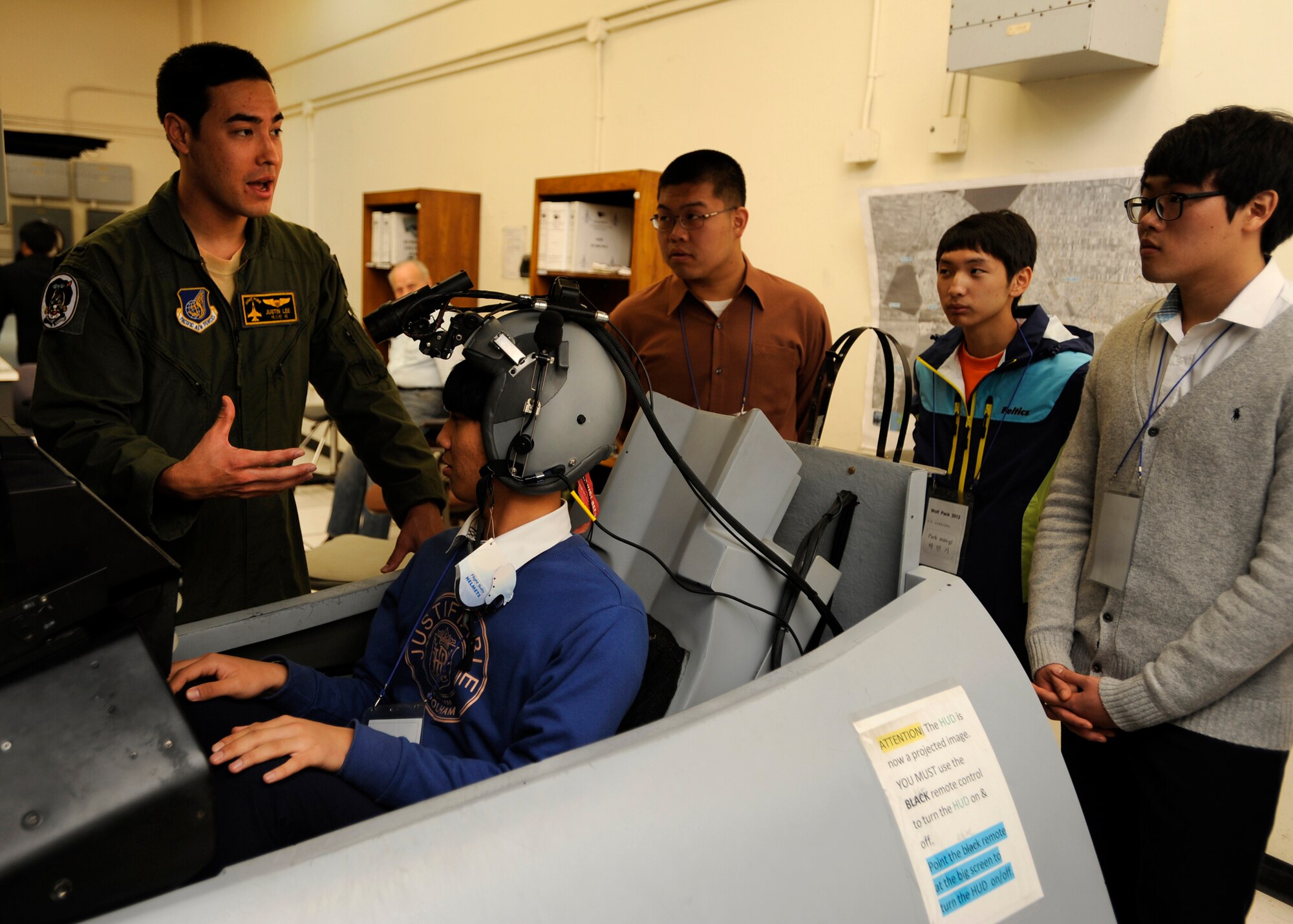 1st Lt. Justin Lee teaches junior and high school students from eight different institutions about the flight simulators during the honorary pilot program at Kunsan Air Base, Republic of Korea, Oct. 24, 2012. The pilots use the simulators to train on anything from taking off and landing to using their weapons systems. (U.S. Air Force photo/Senior Airman Marcus Morris)