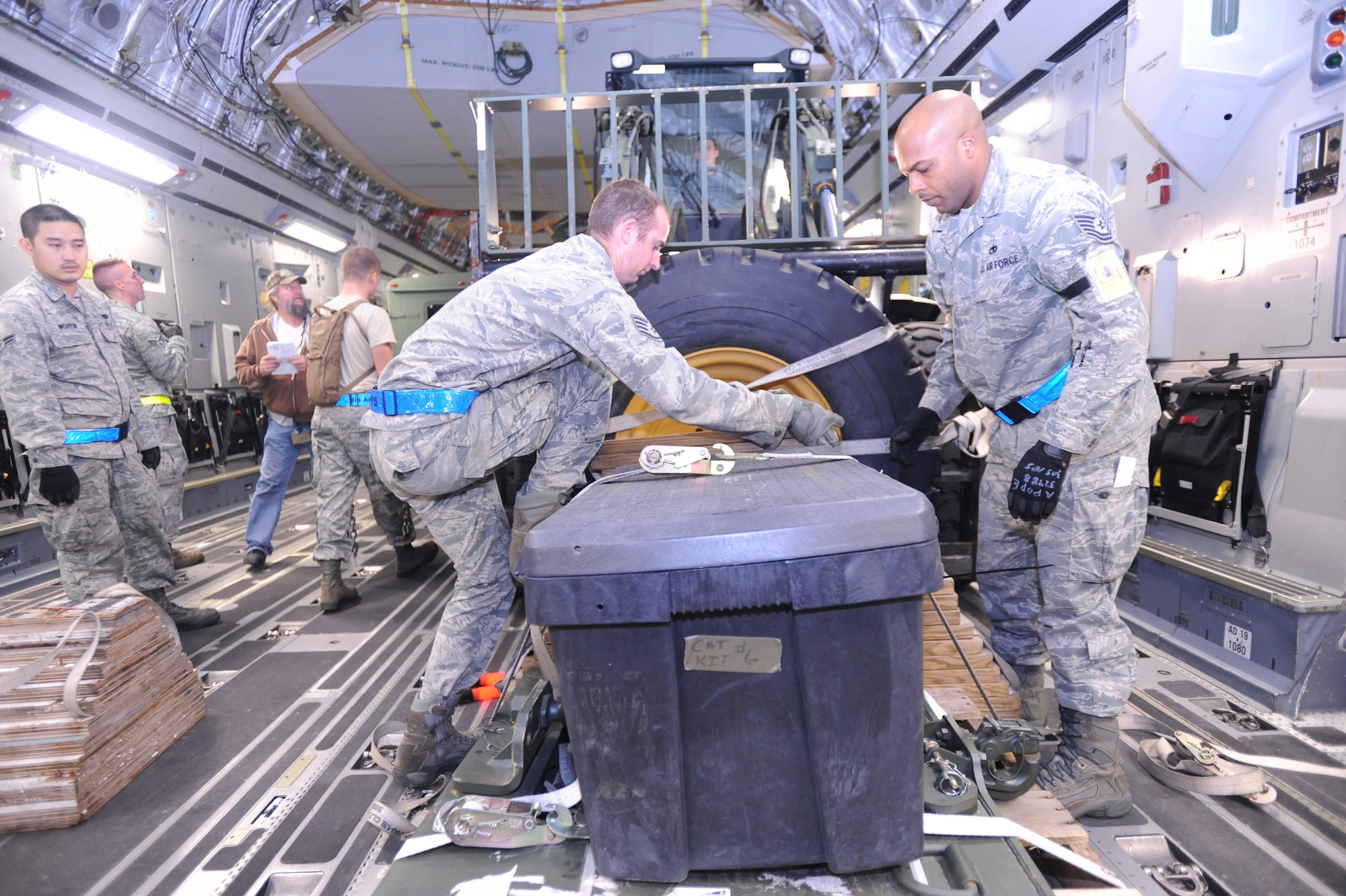 JOINT BASE MCGUIRE-DIX-LAKEHURST, N.J. -- Staff Sgt. Jason Lownes, 305th Aerial Port Squadron ramp supervisor, and Tech. Sgt. Antwon Pope, 305th Aerial Port Squadron shift supervisor, secure cargo loaded onto a C-17 Globemaster III Oct. 27, 2012, at Joint Base McGuire-Dix-Lakehurst. The 621st Contigency Response Wing is moving their equipment to avoid possible damage from approaching Hurricane Sandy. (U.S. Air Force photo by Airman Sean Crowe/ released)