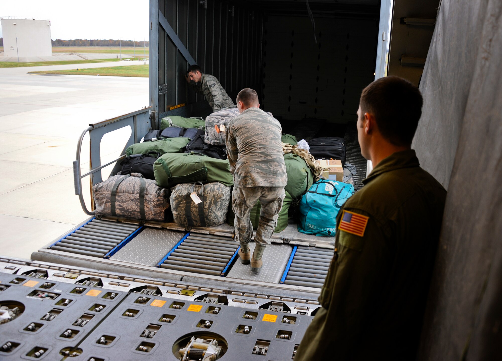 JOINT BASE MCGUIRE-DIX-LAKEHURST, N.J. -- Members of the 605th Aircraft Maintenance Squadron slide a pallet of luggage onto a KC-10 Extender here for transport to Grand Forks Air Force Base, N.D., Oct. 28, 2012. The 305th Air Mobility Wing's aircraft are being evacuated to alternate locations throughout the United States to avoid possible damage from Hurricane Sandy. (U.S. Air Force photo by Staff Sgt. David Carbajal/Released)