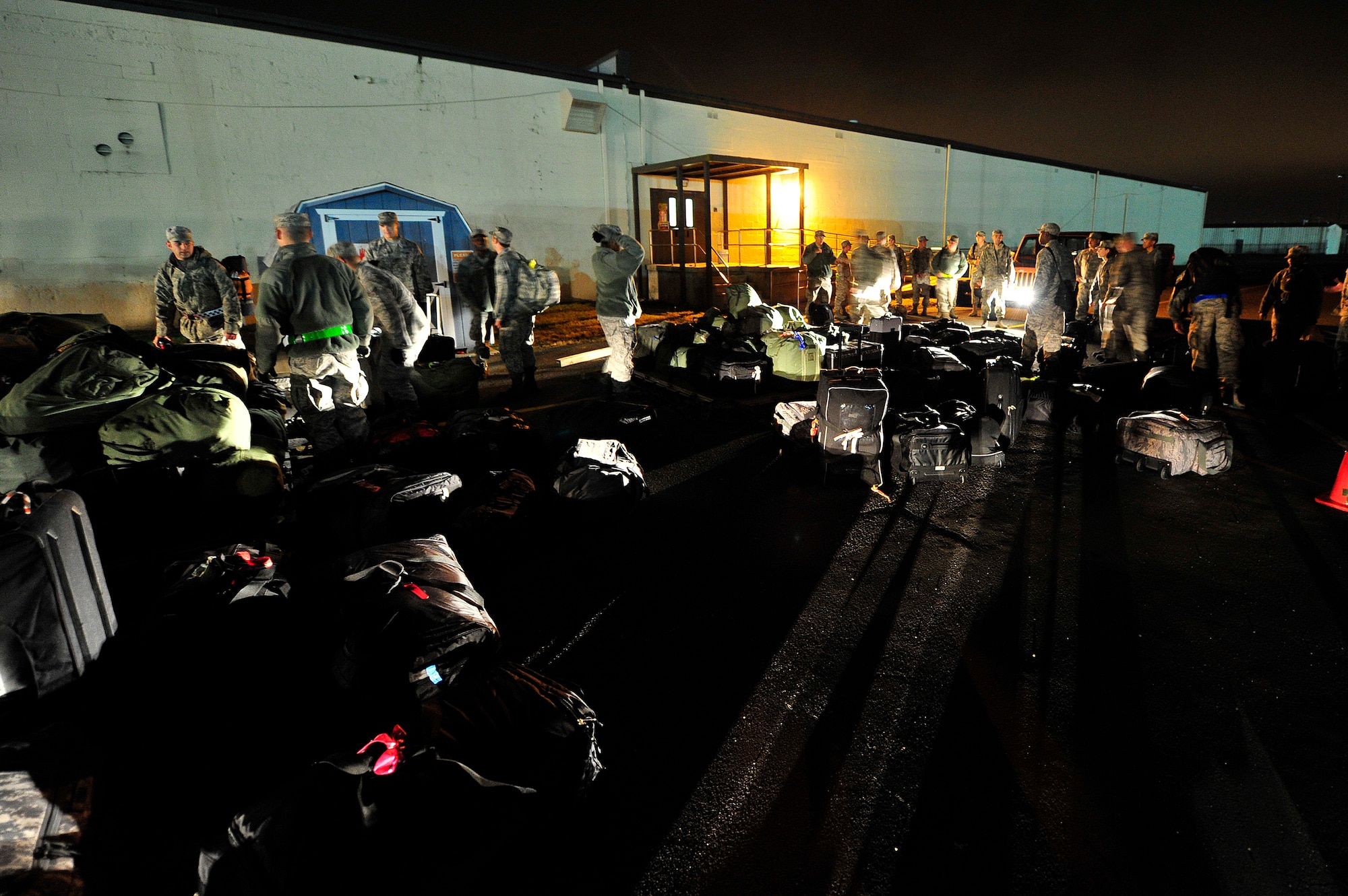 JOINT BASE MCGUIRE-DIX-LAKEHURST, N.J. -- U.S. Air Force Airmen assigned to the 621st Contingency Response Wing at Joint Base McGuire-Dix-Lakehurst, N.J. organize baggage to be loaded onto cargo pallets in the pre-dawn darkness, Oct. 28, 2012.  The CRW was deploying approximately 65 Airmen from an air mobility contingency response team out of the path of Hurricane Sandy. This movement will ensure Air Mobility Command maintains the capability to respond to natural disasters or worldwide contingencies.   (U.S. Air Force photo by Tech. Sgt.  Parker Gyokeres) (Released)