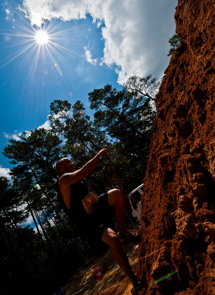 A runner sprints up a tall dirt mound near the end of the Emerald Coast MudRun for Orphans May 19 in Niceville, Fla.  Active-duty and reserve service members from Duke, Hurlburt Field, Eglin and more came out to get dirty in either the morning or afternoon 5K challenges. (U.S. Air Force photo/Tech. Sgt. Samuel King Jr.)
