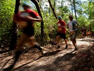 Runners sprint through the woods at the beginning of Emerald Coast MudRun for Orphans May 19 in Niceville, Fla.  Active-duty and reserve service members from Duke, Hurlburt Field, Eglin and more came out to get dirty in either the morning or afternoon 5K challenges. (U.S. Air Force photo/Tech. Sgt. Samuel King Jr.)
