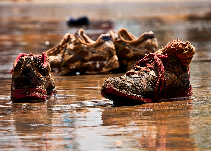 Muddy sneakers and socks sit soaking in the muddy water as participants of the Emerald Coast MudRun for Orphans clean up and wash off May 19 in Niceville, Fla.  Active-duty and reserve service members from Duke, Hurlburt Field, Eglin and more came out to get dirty in either the morning or afternoon 5K challenges. (U.S. Air Force photo/Tech. Sgt. Samuel King Jr.)