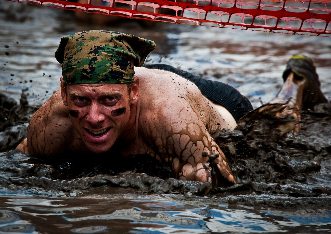 A military member crawls through the first water obstacle May 19 at the Emerald Coast MudRun for Orphans in Niceville, Fla.  Active-duty and reserve service members from Duke, Hurlburt Field, Eglin and more came out to get dirty in either the morning or afternoon 5K challenges. (U.S. Air Force photo/Tech. Sgt. Samuel King Jr.)