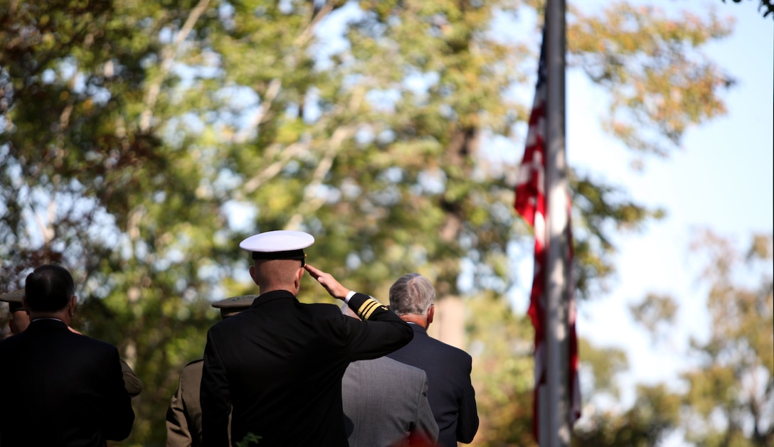 Service members salute the American flag while the 2nd Marine Division band plays the National Anthem during the Beirut Memorial Service Ceremony in Jacksonville, N.C., Oct. 23. This year marks 29 years after the Beirut bombing, which is observed at the memorial every year.