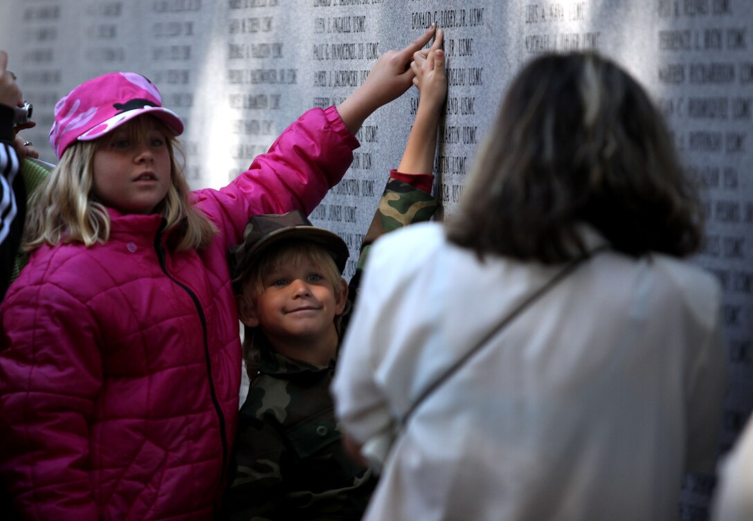 A boy and a girl point to the name of a fallen Marine during the Beirut Memorial Service Ceremony in Jacksonville, N.C., Oct. 23. Names are inscribed on the wall of the Beirut Memorial to honor the service members who died the Beirut attack in 1983.