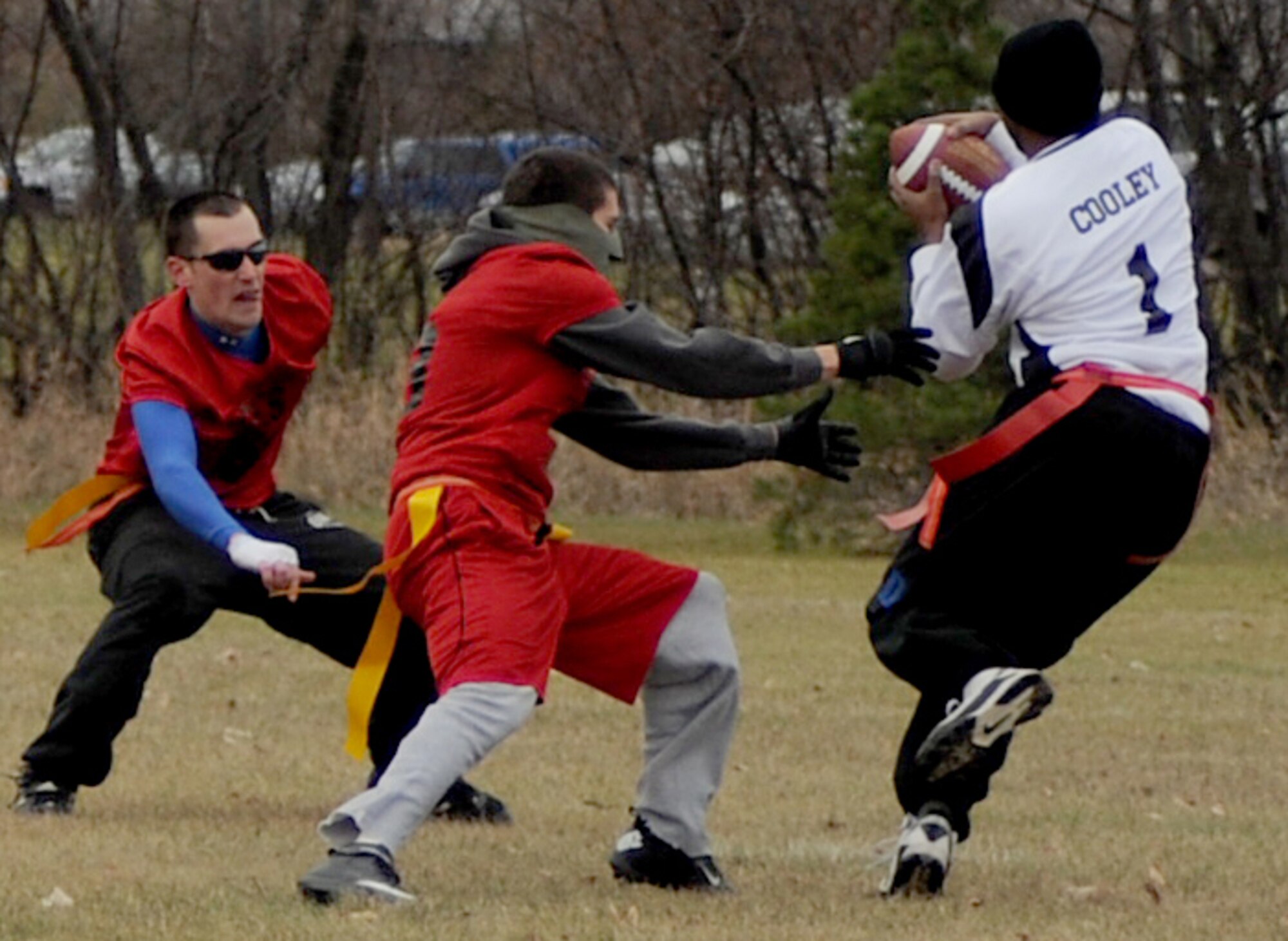 Staff Sgt. Louis Cooley, 319th Security Forces Squadron, evades defenders from the 319th Civil Engineering Squadron on his way toward the end zone during the intramural flag football championship Oct. 27, 2012, on Grand Forks Air Force Base, N.D. The 319th SFS defeated the 319th CES by a score of 19-6. (U.S Air Force photo/Airman 1st Class Ashley Taylor)