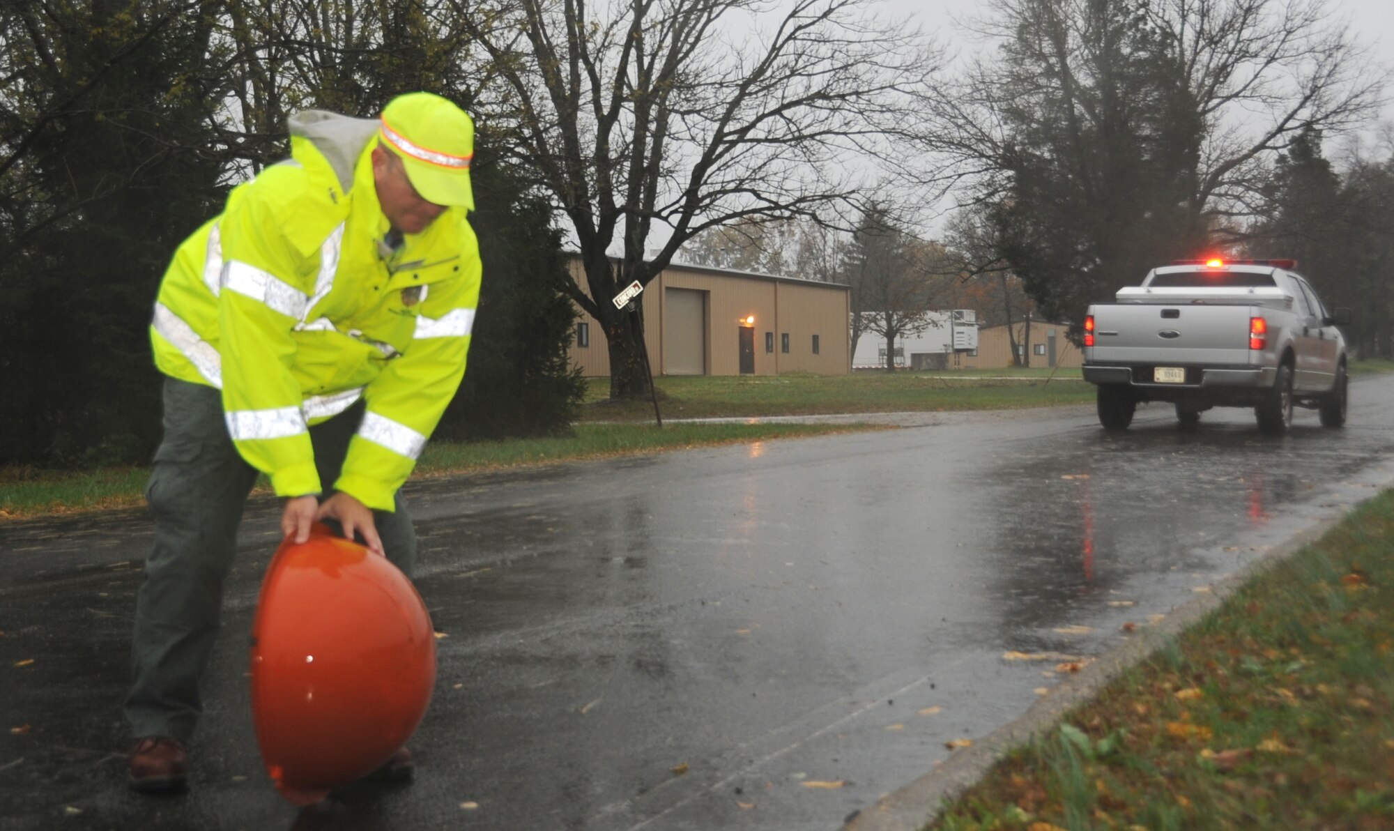 JOINT BASE MCGUIRE-DIX-LAKEHURST, N.J. -- Bill Goldsberry, Joint Base McGuire-Dix-Lakehurst Safety Office, clears a power line cover from the street Oct. 29, 2012. Goldsberry performed a safety inspection of JB MDL prior to the landfall of Hurricane Sandy. (U.S. Air Force photo by 2nd Lt. Alexis McGee/Released)