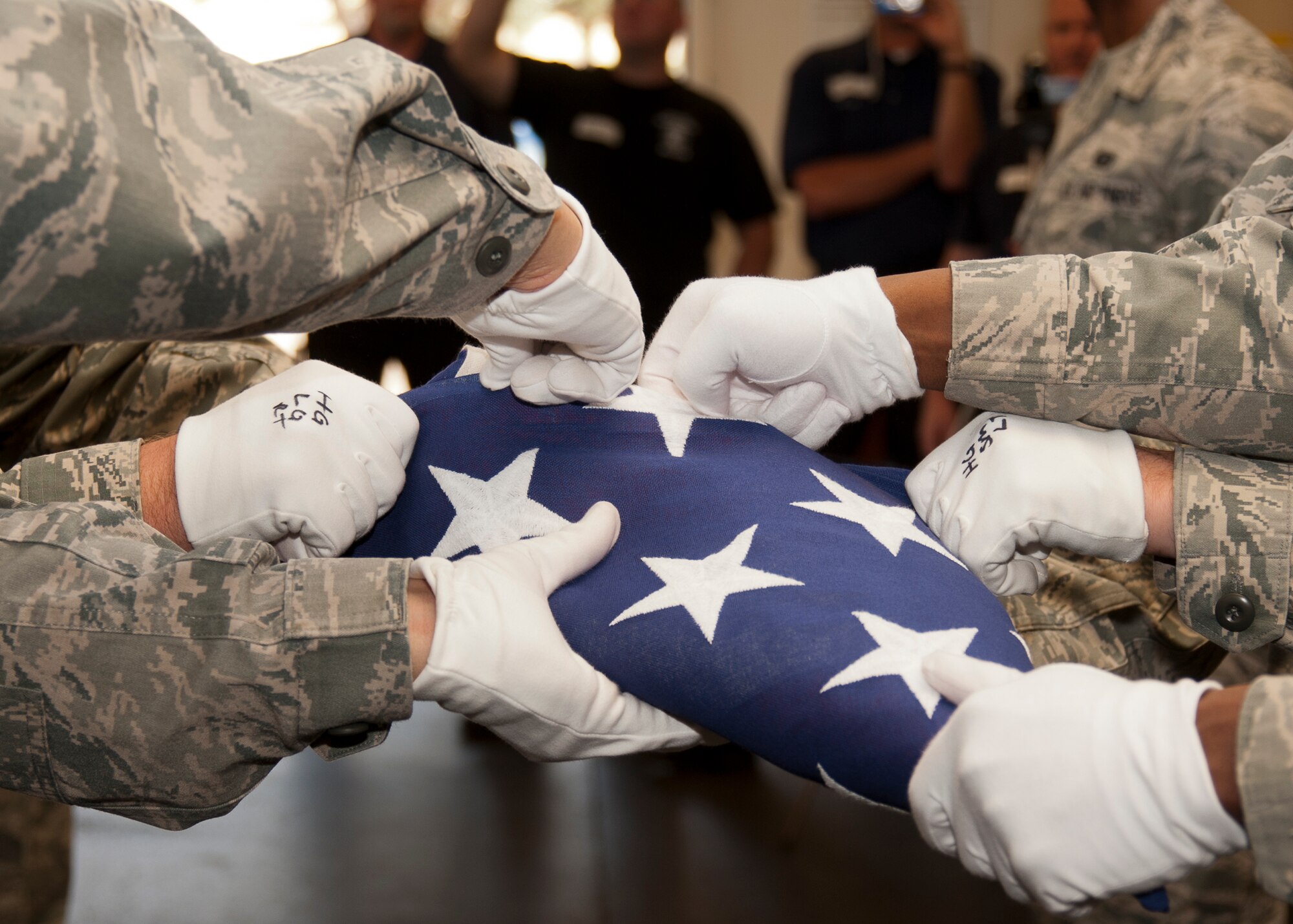 Team members of the Travis Air Force Base Honor Guard demonstrate six man flag folding to local firemen and police.   (Released - U.S. Air Force Photograph/Heide Couch)
