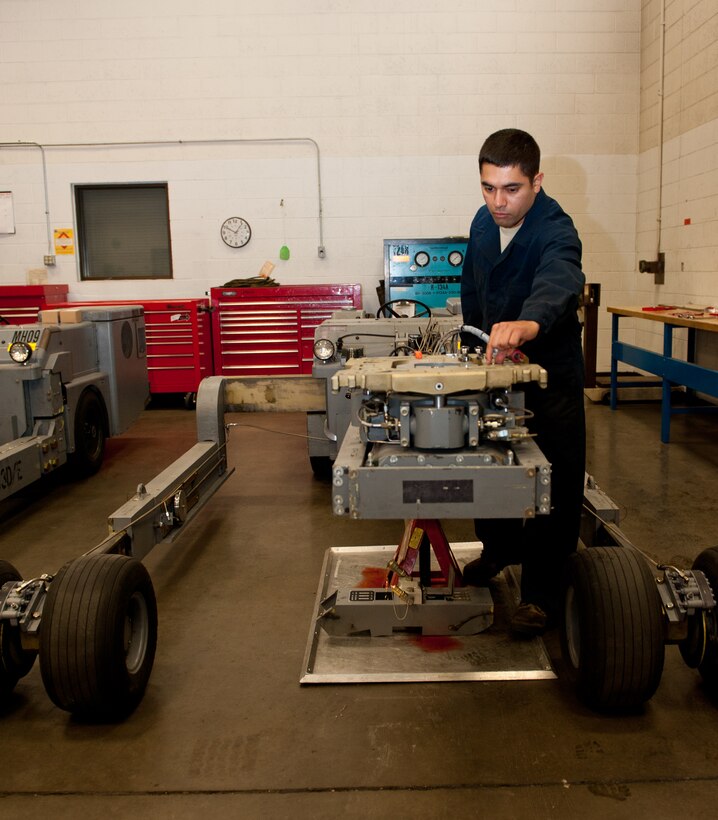 Staff Sgt. George Solis, 28th Maintenance Squadron aerospace ground equipment technician, places a cotter pin during scheduled maintenance on a munitions truck in the AGE shop on Ellsworth Air Force Base, S.D., Oct. 25, 2012. AGE Airmen maintain and service more than 600 pieces of support equipment on Ellsworth. (U.S. Air Force photo by Airman 1st Class Kate Thornton-Maurer/Released)