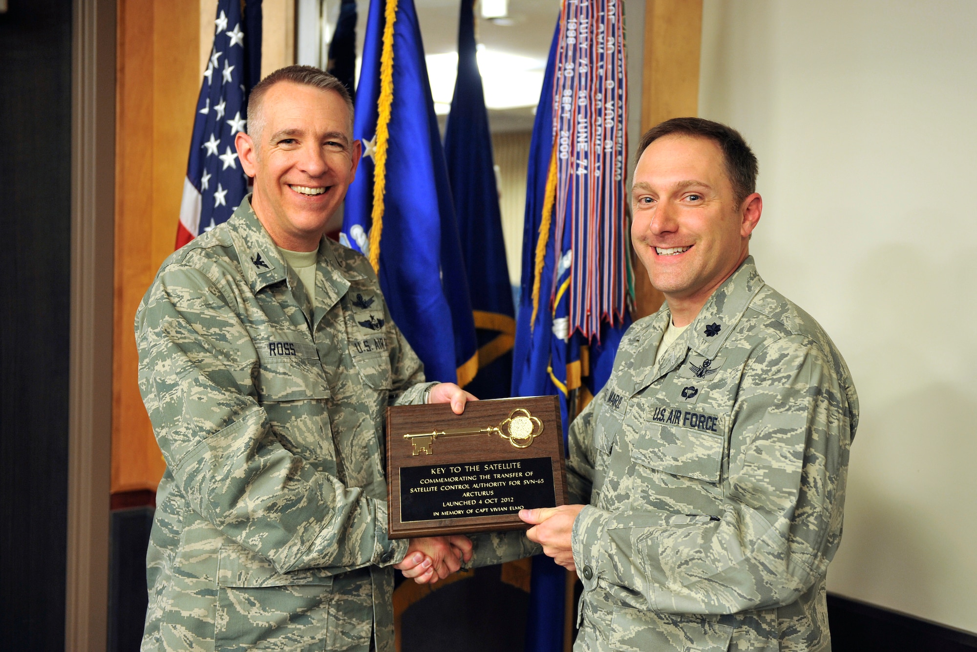 Col. James Ross, 50th Space Wing commander, ceremoniously transfers command and control of the third Global Positioning System Block IIF satellite to Lt. Col. Thomas Ste. Marie, 2nd Space Operations Squadron commander, here Oct. 26. (U.S. Air Force photo/Dennis Rodgers