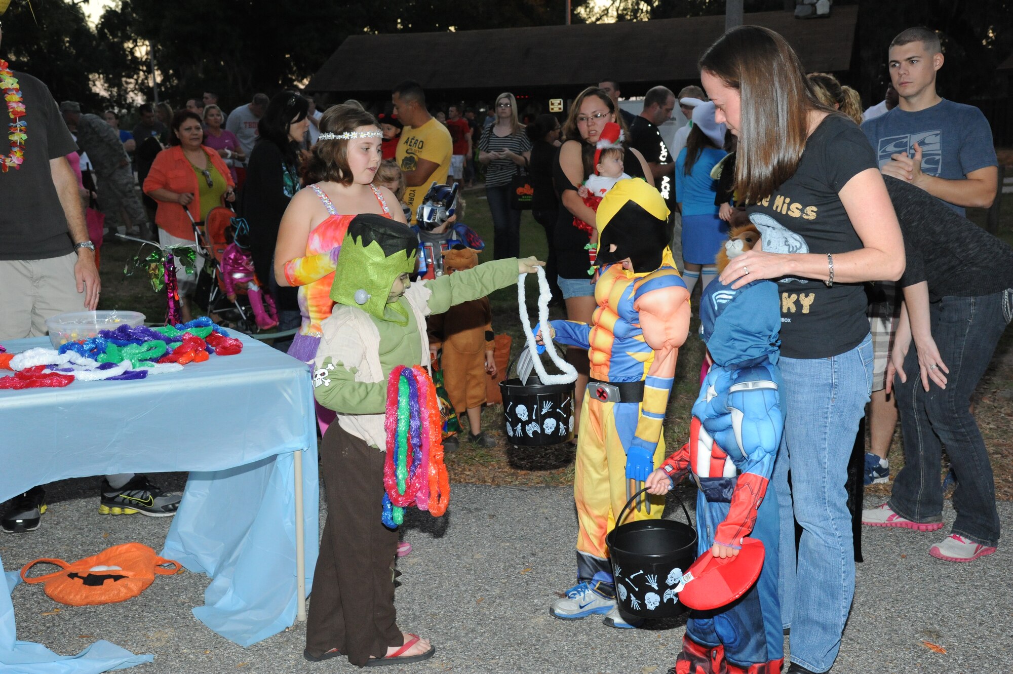 Curtiss Bjorge, 5, son of Cyndy and Staff Sgt. Mike Bjorge, 338th Training Squadron, passes out leis to trunk or treaters such as Alex Smith, 6, and his brother, Zachary, 4, during Ghouls in the Park Oct. 26, at the Marina Park, Keesler Air Force Base, Miss.  The event included a haunted house, trunk or treat, hay ride and music.  Keegan is the grandson of retired Navy member Julie Cramer of Gulfport.  Alex and Zachary’s parents are Master Sgts. Sarah Smith, 336th Training Squadron and Joe Smith, 81st Training Support Squadron.  (U.S. Air Force photo by Kemberly Groue)