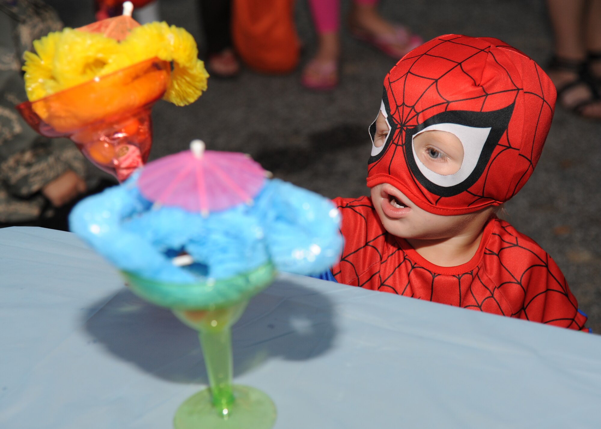 One-year-old Keegan Wasserloos, dressed as spider man, helps himself to a souvenir during Ghouls in the Park Oct. 26, at the Marina Park, Keesler Air Force Base, Miss.  The event included a haunted house, trunk or treat, hay ride and music.  Keegan is the grandson of retired Navy member Julie Cramer of Gulfport.  (U.S. Air Force photo by Kemberly Groue)