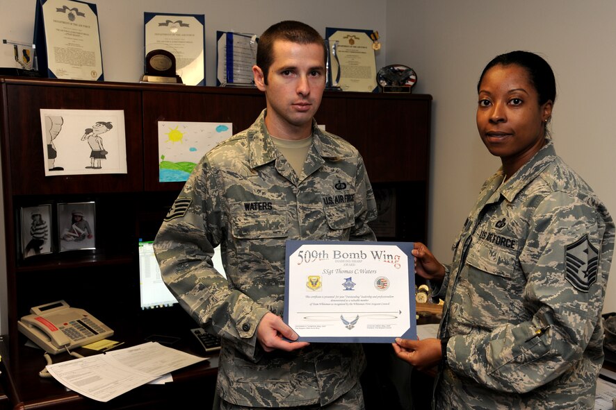 Master Sgt. Lafoundra Thompson 509th Bomb Wing First Sergeant, presents Staff Sgt. Thomas Waters 509th Comptroller Squadron budget supervisor, with a Diamond Sharp certificate in behalf of the First Sergeant’s council at Whiteman Air Force Base, Oct. 29. The Diamond Sharp award is the First Sergeants Council’s recognition for Airmen who have stood out while performing the mission. Waters was chosen by the council out of three nominees. (U.S. Air Force photo/Senior Airman Montse Belleau) (Released)