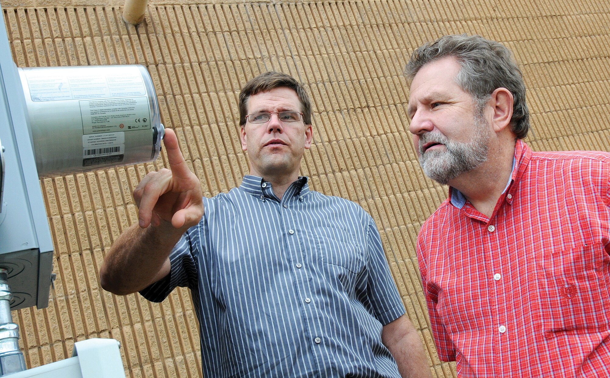 Being No. 1 isn’t a title Tinker Air Force Base wants when it comes to energy consumption. Mark McWhirter, left, and Gary Krivokapich are two new 72nd Civil Engineering Directorate employees focused to help take the base out of that ranking. The men discuss one of the advanced meter reading systems, this one outside Bldg. 210, that through radio signals sends energy usage information back to CE to pinpoint trends, helping CE find options to use less and save more. (Air Force photo by Margo Wright)