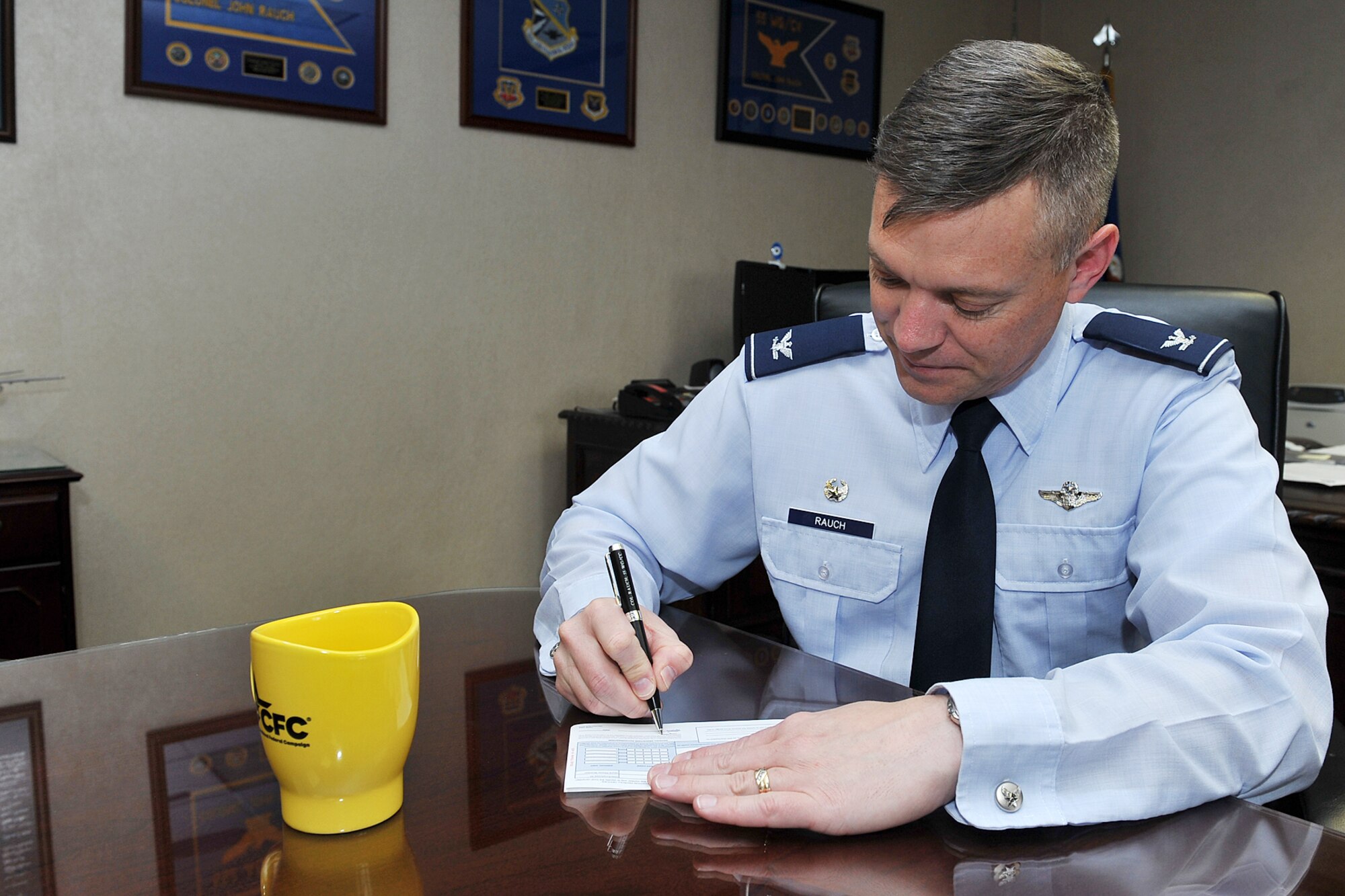 U.S. Air Force Col. John Rauch, 55th Wing commander, fills out a Combine Federal Campaign pamphlet inside the 55th Wing headquarters building on Offutt AFB, Neb., Oct. 26. The mission of the CFC is to promote and support philanthropy through a program that is employee focused, cost-efficient, and effective in providing all federal employees the opportunity to improve the quality of life for all.