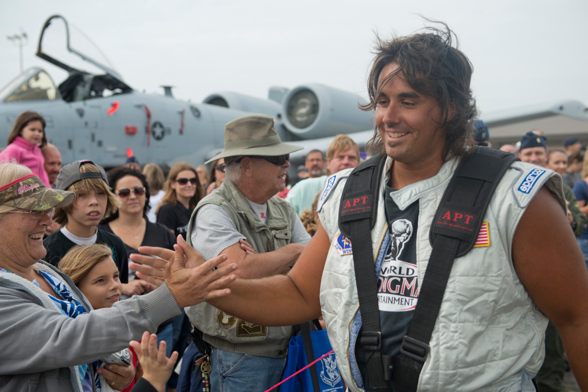 Mark Kirsch, strong man for "Man vs. Jumbo Jets", high-fives crowd members during the Moody Air Force Base, Ga., Legacy of Liberty Open House air show Oct. 27, 2012. The crowd gave their support as Kirsch prepared to pull an HC-130P Combat King. (U.S. Air Force photo by Senior Airman Douglas Ellis/Released)
