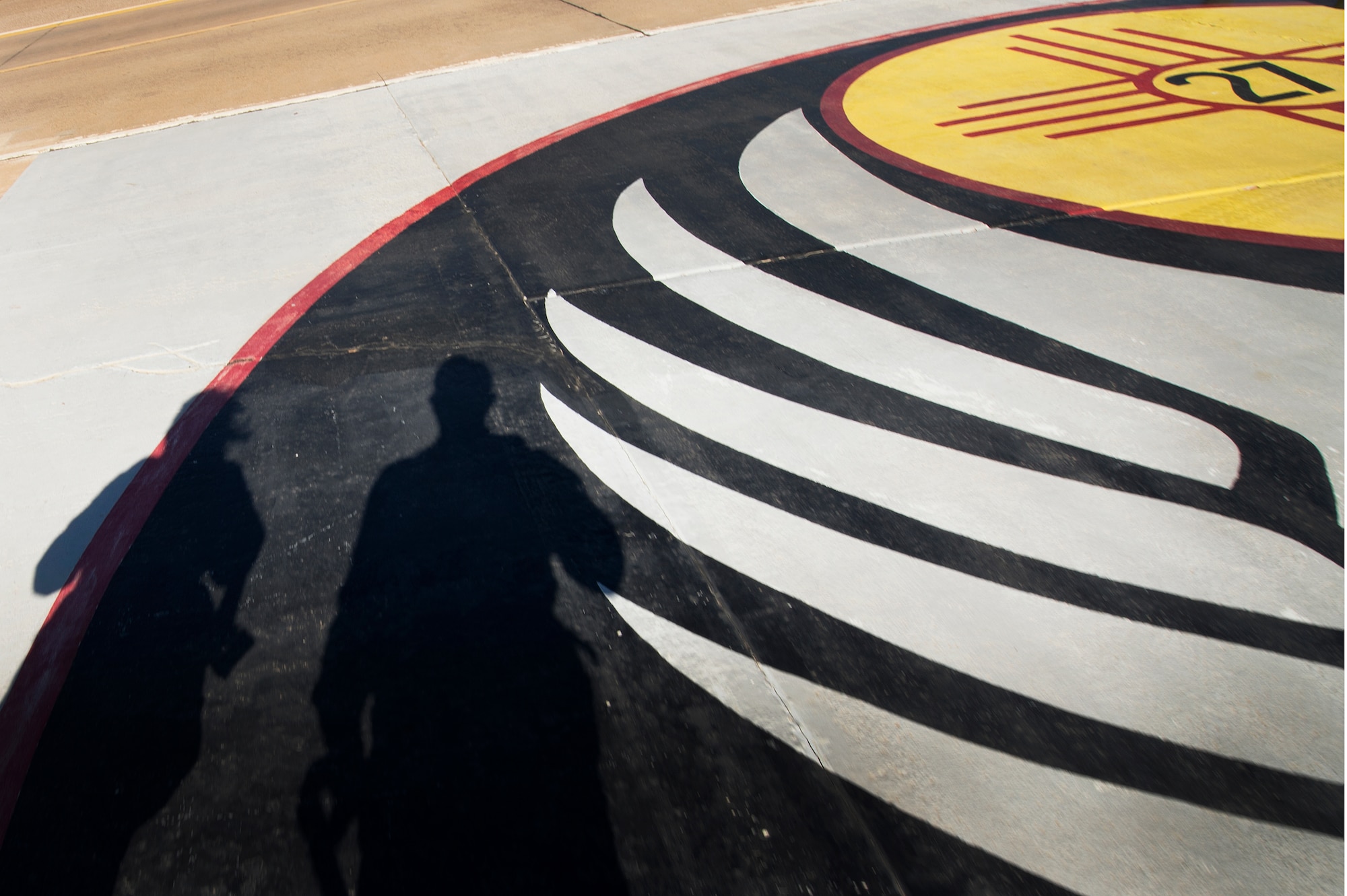 U.S. Air Force Airman 1st Class Ericka Englbom and Staff Sgt. Matthew Plew depart the flight line after documenting a CV-22 Osprey flight for Air Commando spouses at Cannon Air Force Base, N.M., Oct. 27, 2012. Cannon's annual Spouses Orientation Flights offer a rare opportunity for husbands and wives to take to the skies in a military aircraft. (U.S. Air Force photo/Staff Sgt. Matthew Plew)